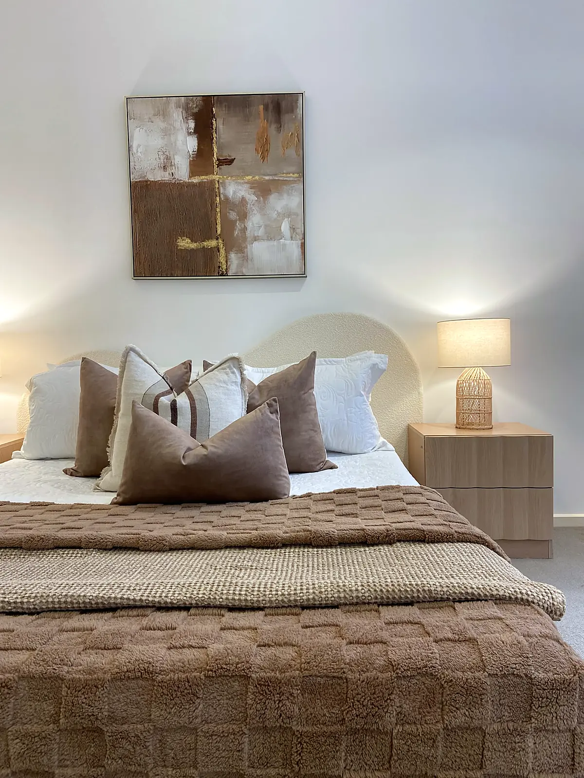 Bedroom styled with warm brown quilt and artwork in a Kew townhouse