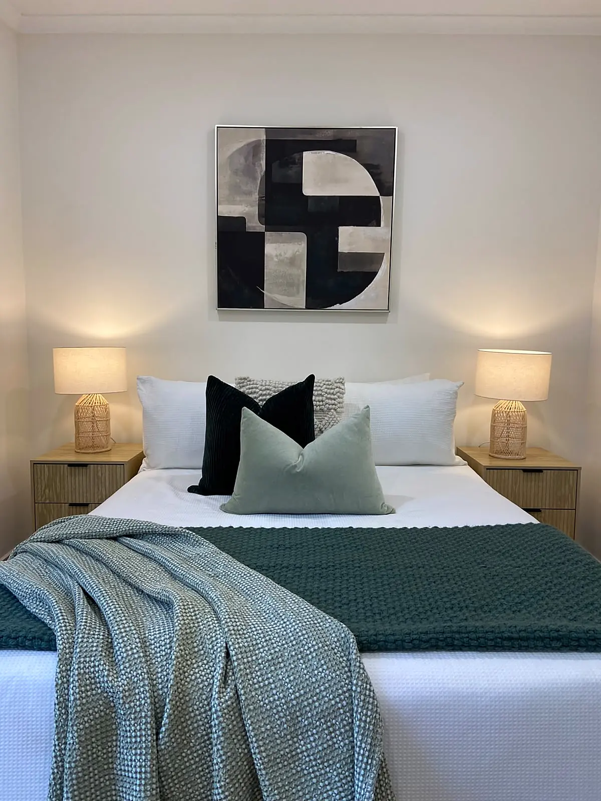 Main bedroom staged with teal throw and abstract artwork in a Kings Park home