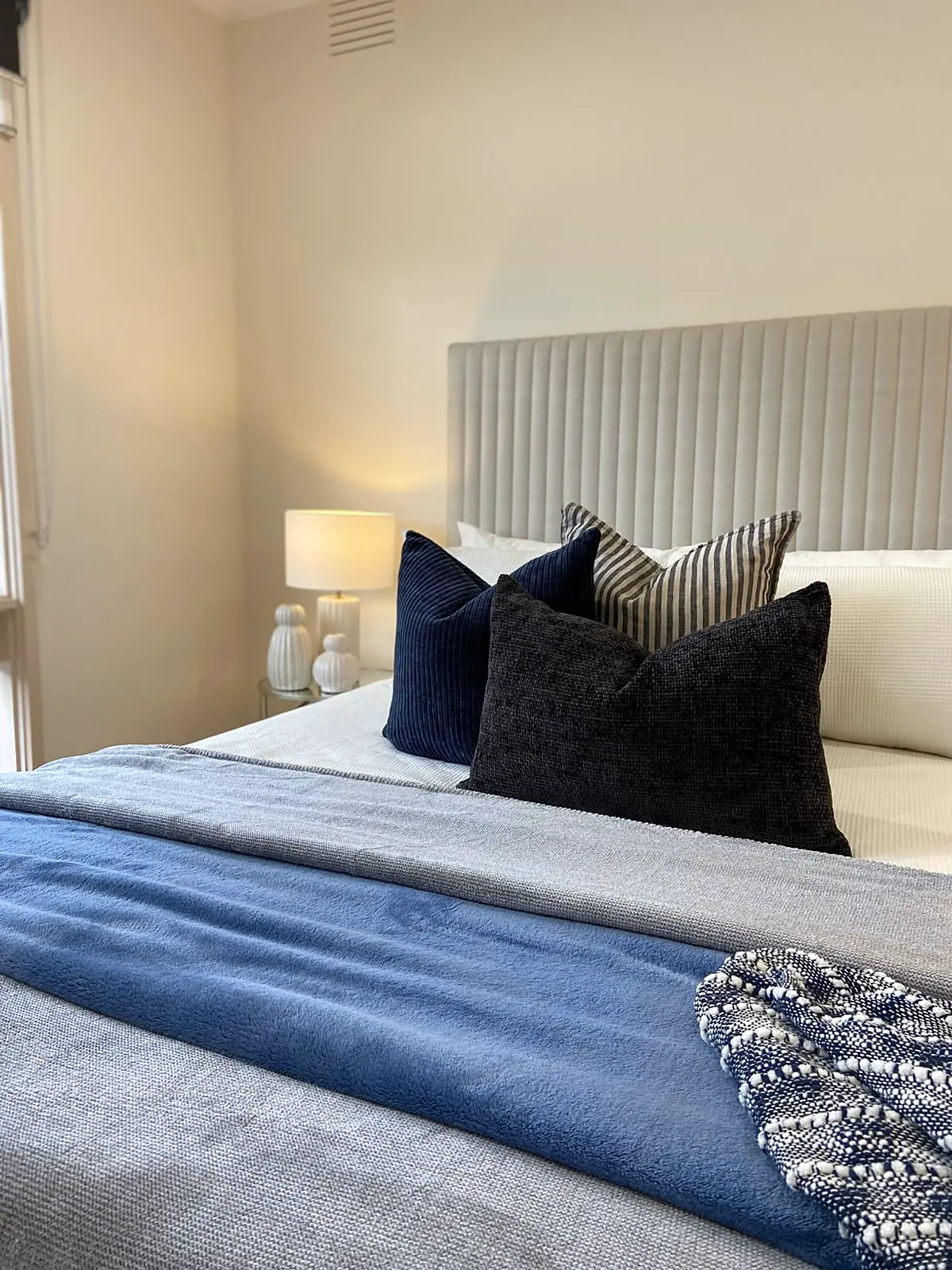 Bedroom styled with navy cushions and blue throw in a Kings Park home