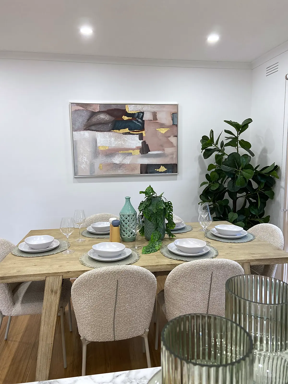 Timber dining table with rounded cream chairs in a staged Kings Park home