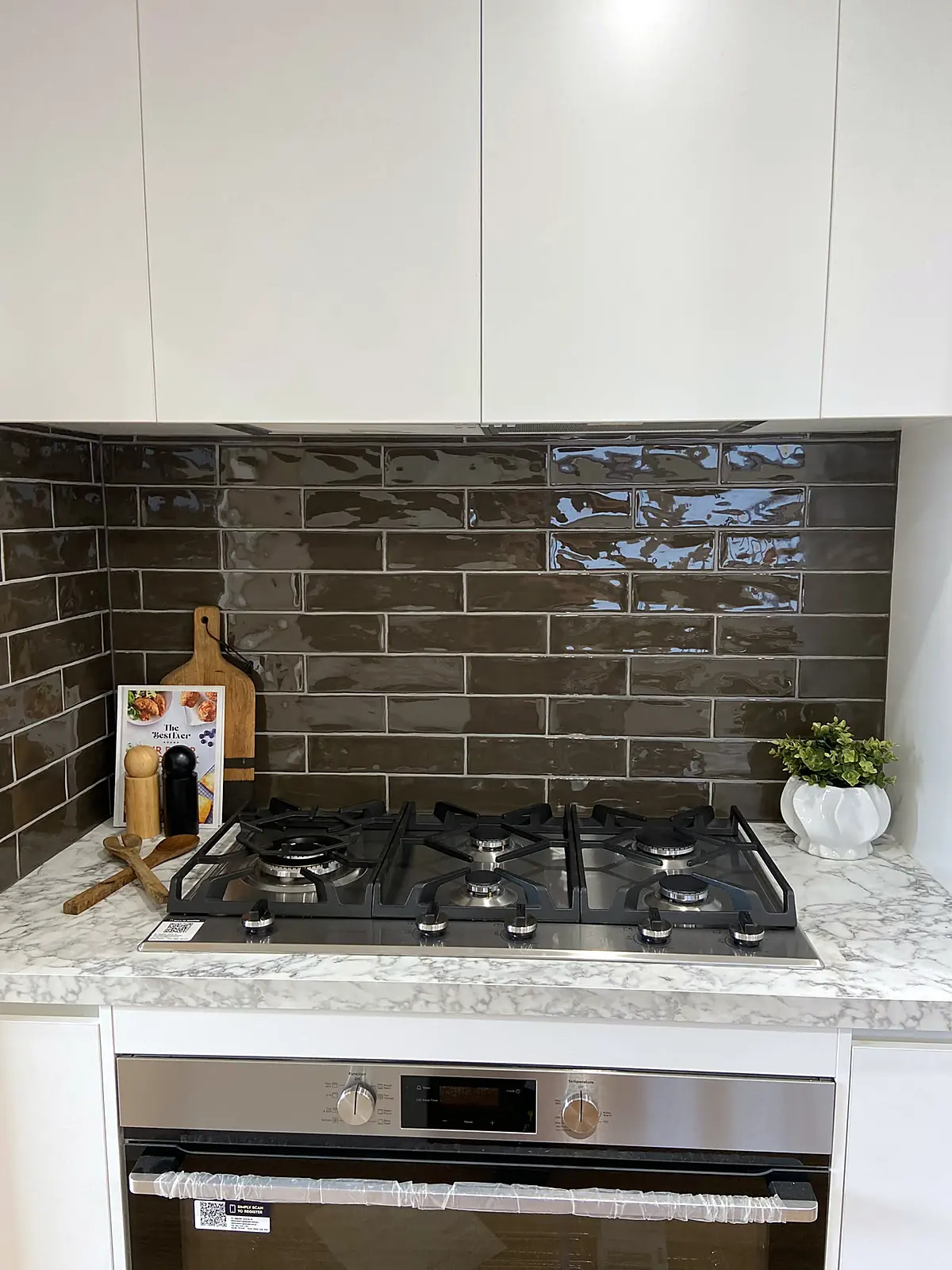 Renovated kitchen with dark tiled splashback styled in a Kings Park home