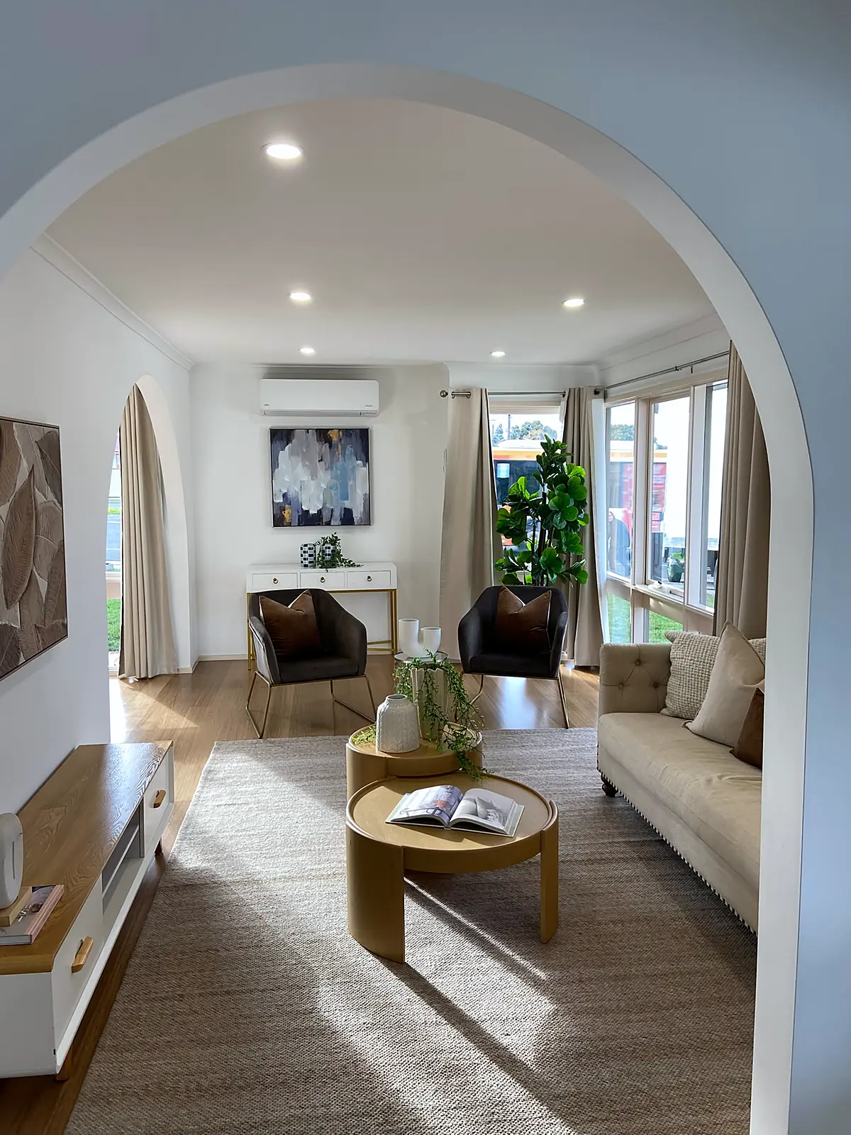 View through an arched doorway to the staged living room in a Kings Park home