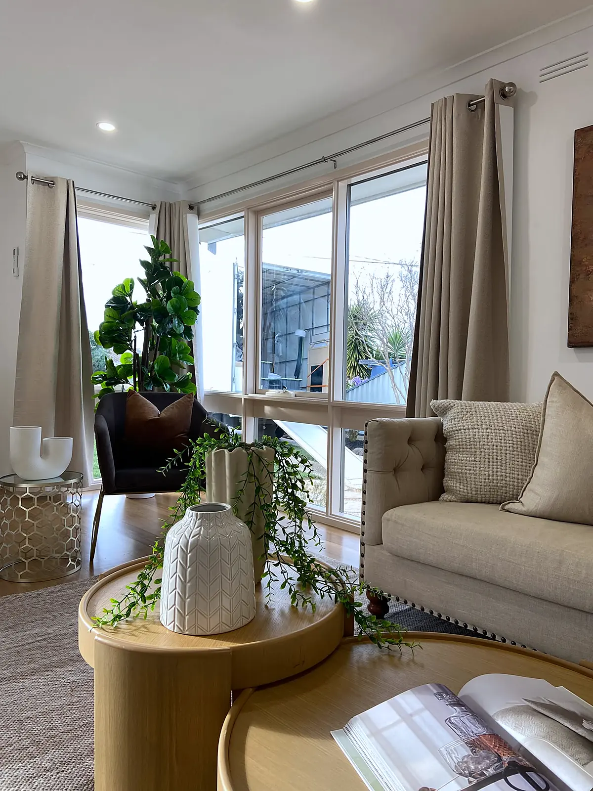 Sofa beside wide windows with plants in a staged Kings Park living room