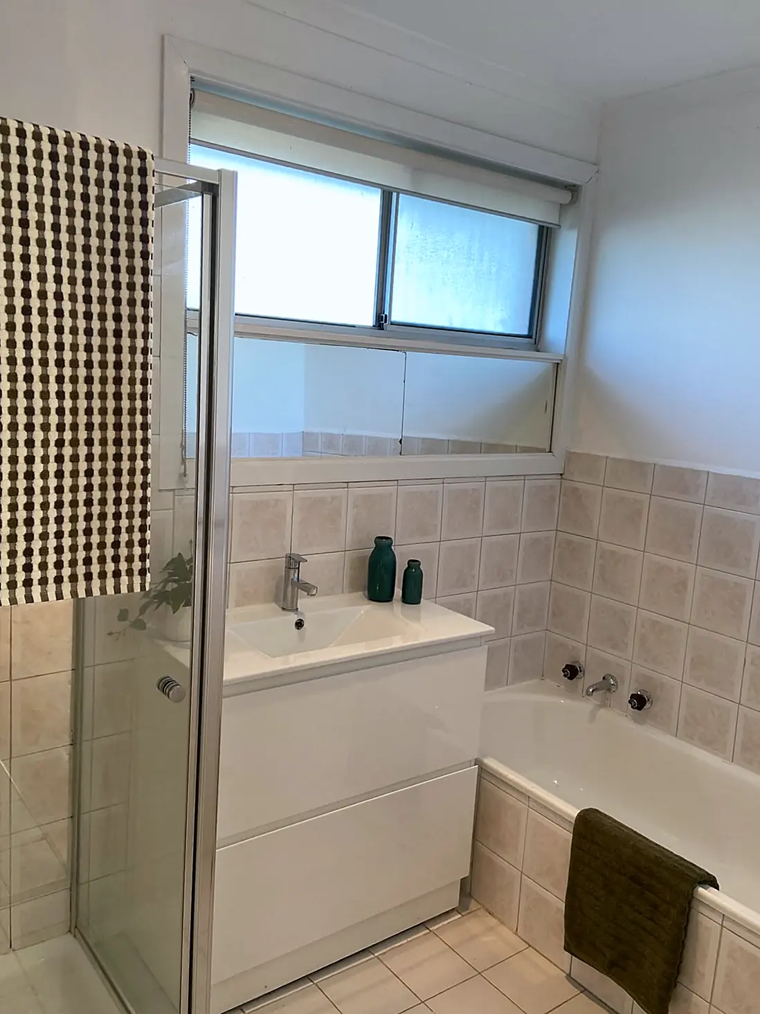 Bathroom styled with towels and green accents in a Lalor unit