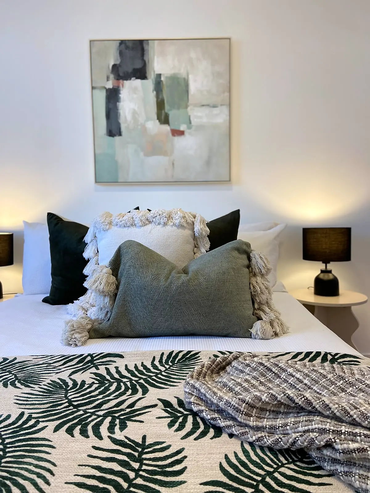 Bedroom styled with fern print quilt and green cushion in a Lalor unit