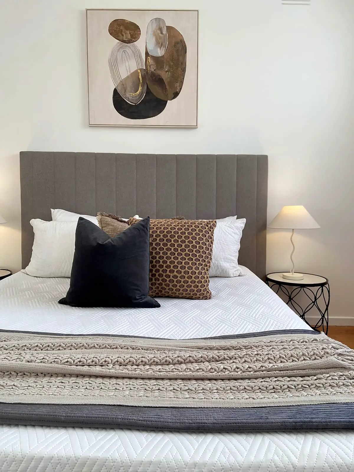 Bedroom staged with upholstered bedhead and layered neutral linen in a Lalor unit