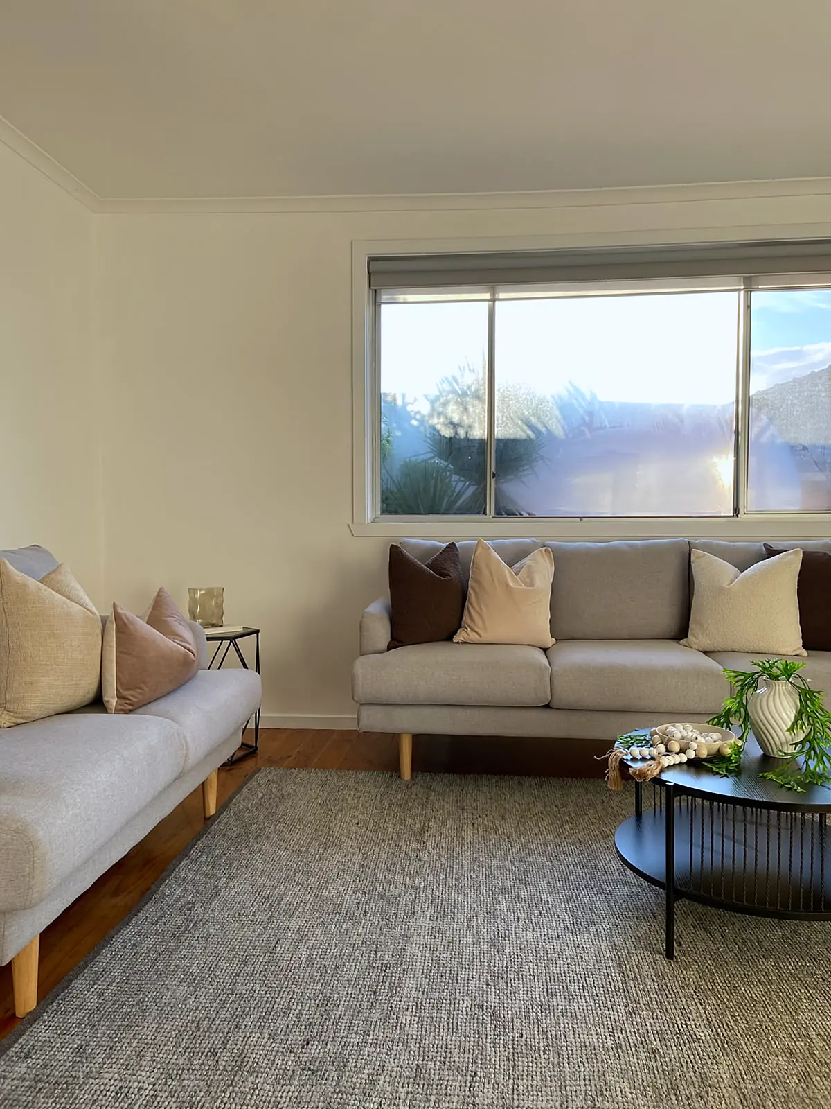 Lounge staged with light linen sofas and textured rug in a Lalor unit