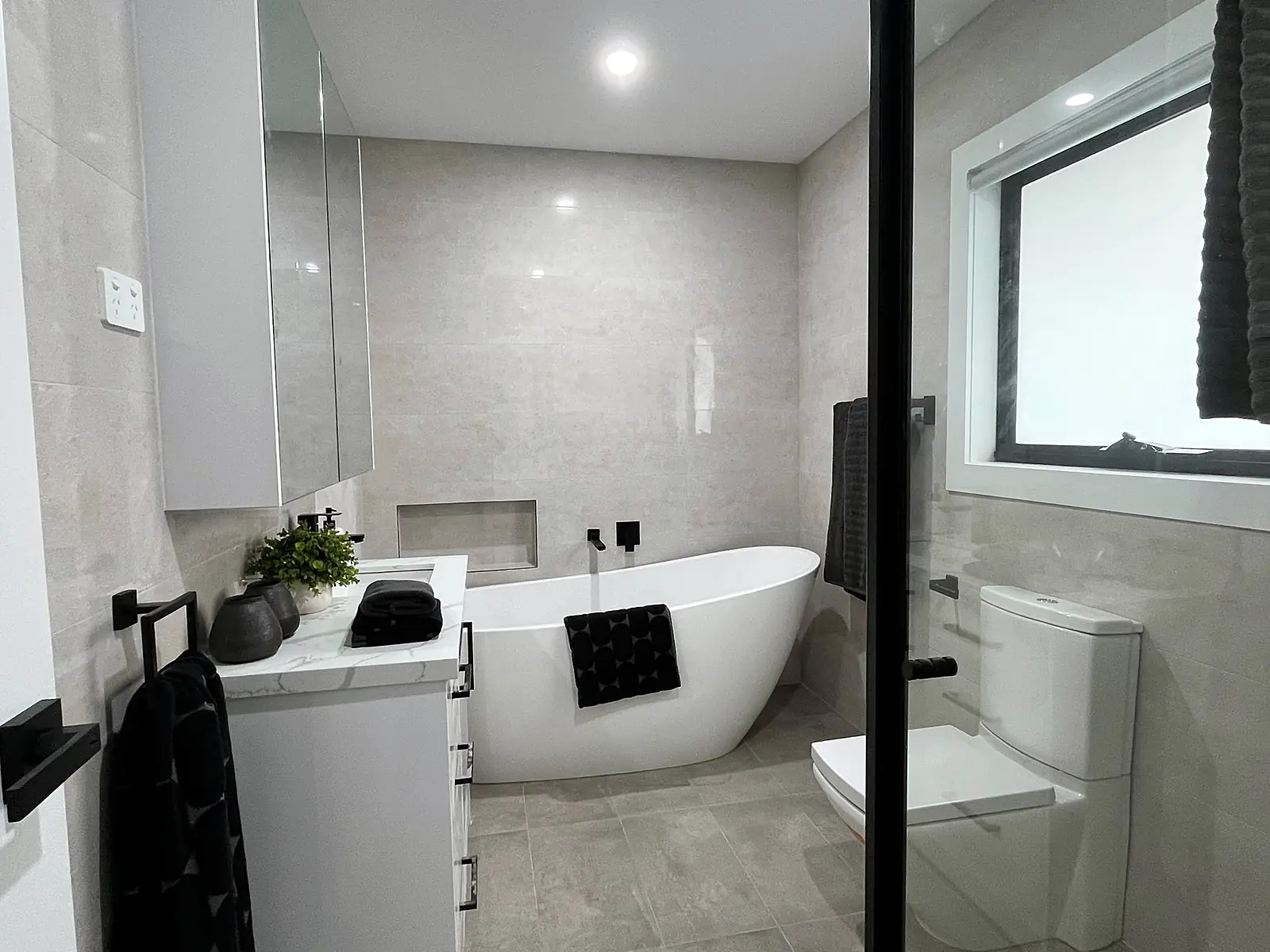 Bathroom with freestanding bath styled with towels in a Laverton home