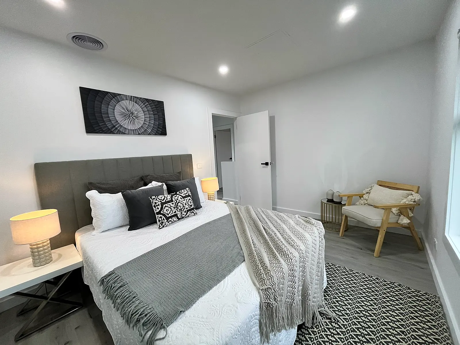Bedroom staged with dark bedhead and patterned cushions in a Laverton home