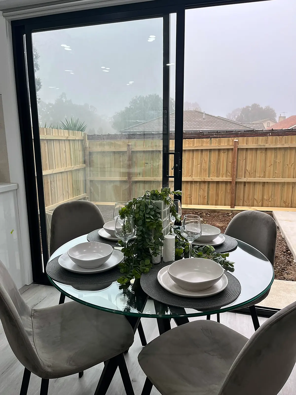 Round glass dining table by the courtyard doors in a staged Laverton home