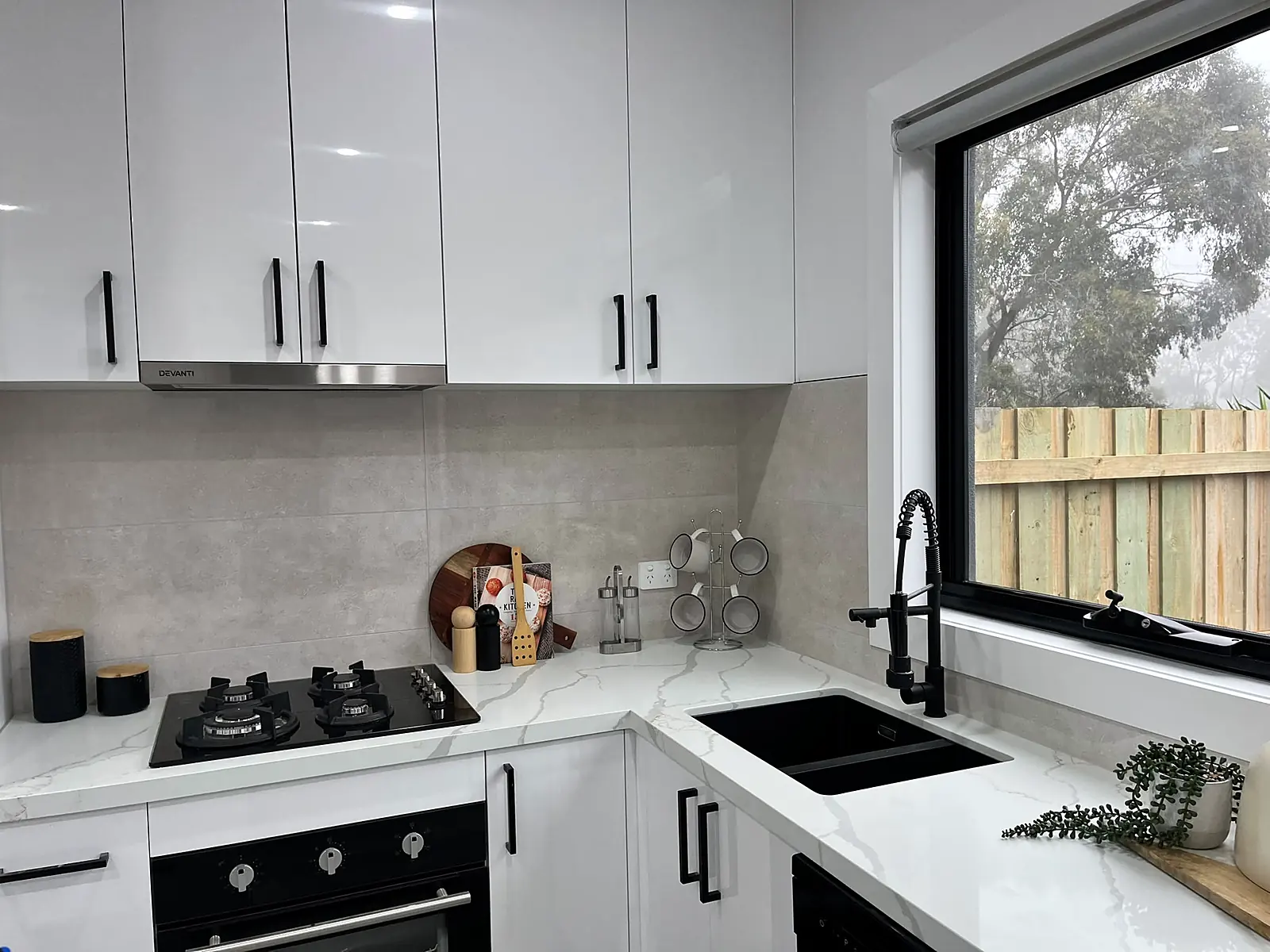 White kitchen with black tapware styled for sale in a Laverton home