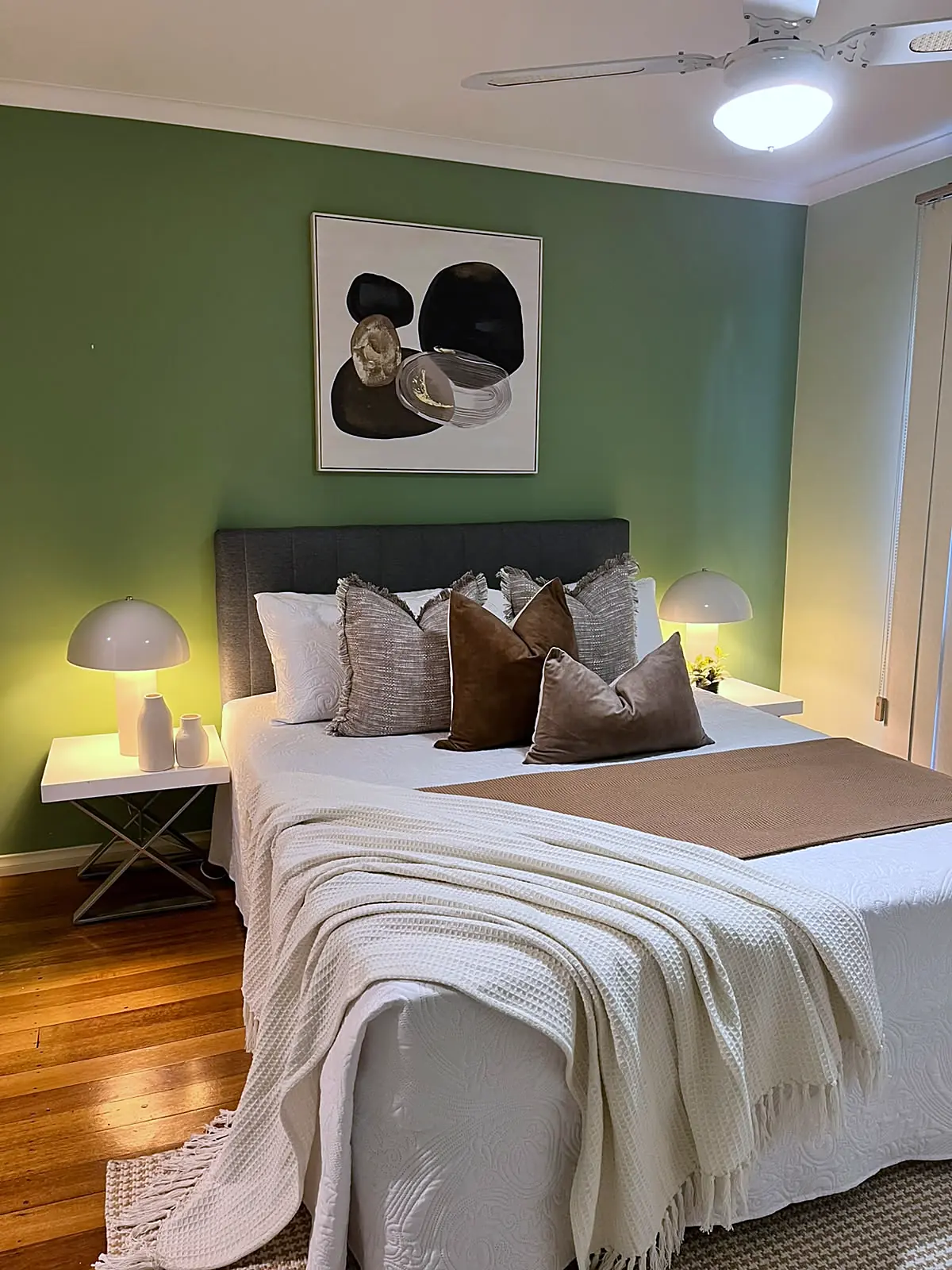 Bedroom with green wall styled in neutral linen in a Melton home