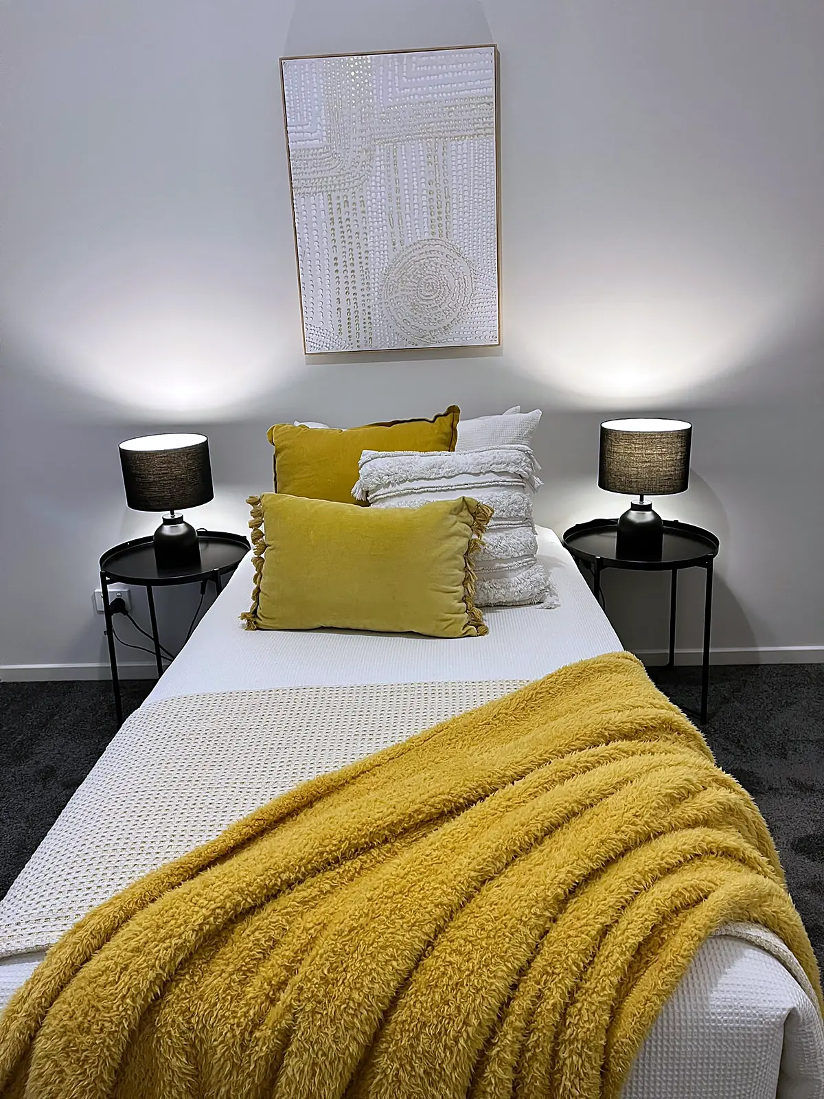 Bedroom staged with mustard throw and black side tables in a Mernda home