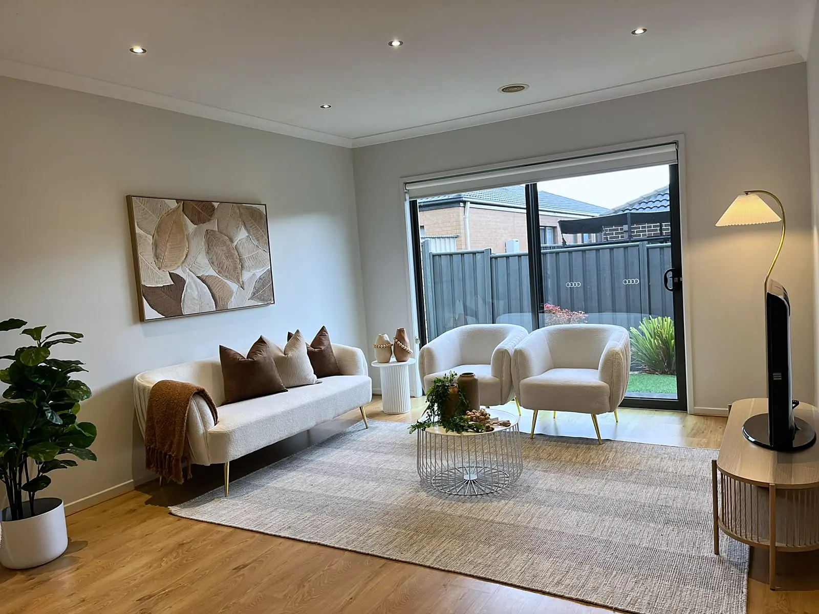 Staged family room with cream sofa and armchairs in a Mernda home