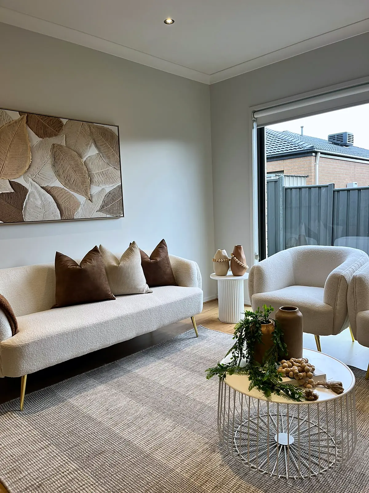 Living room styled with curved sofa and leaf artwork in a Mernda home