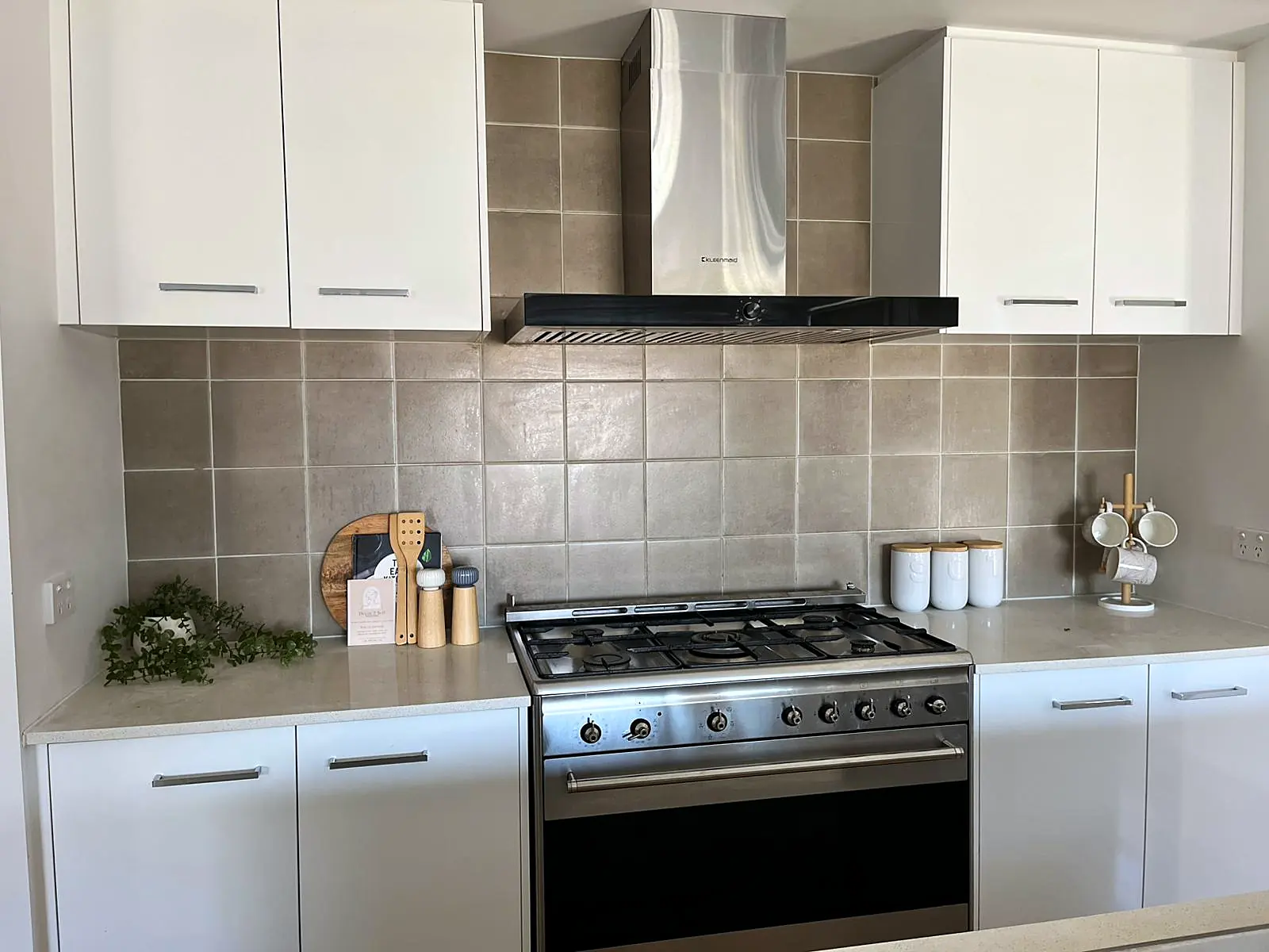 White kitchen styled with boards and canisters in a Mickleham home