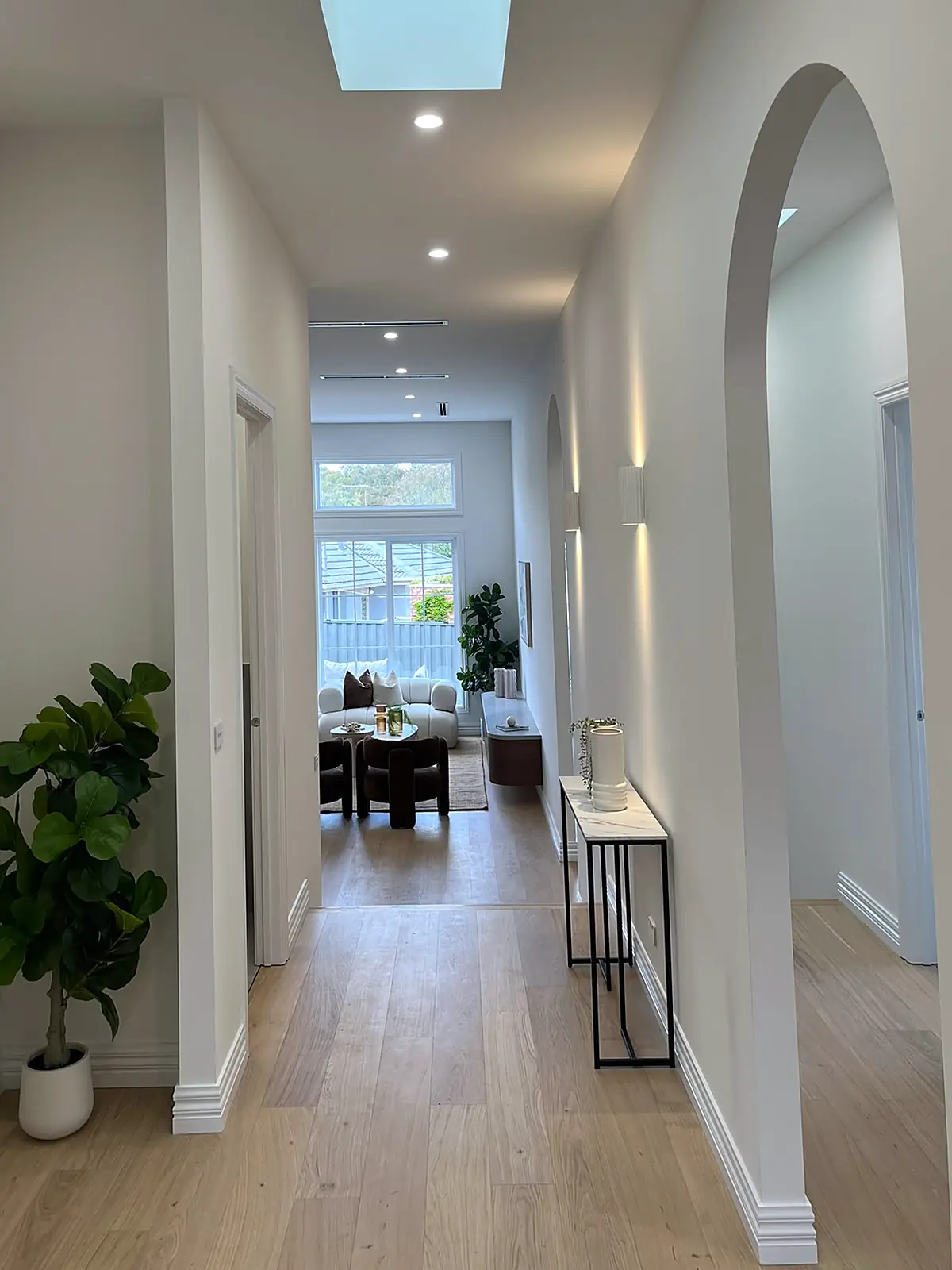 Arched hallway styled with console table and plant in an Oak Park home