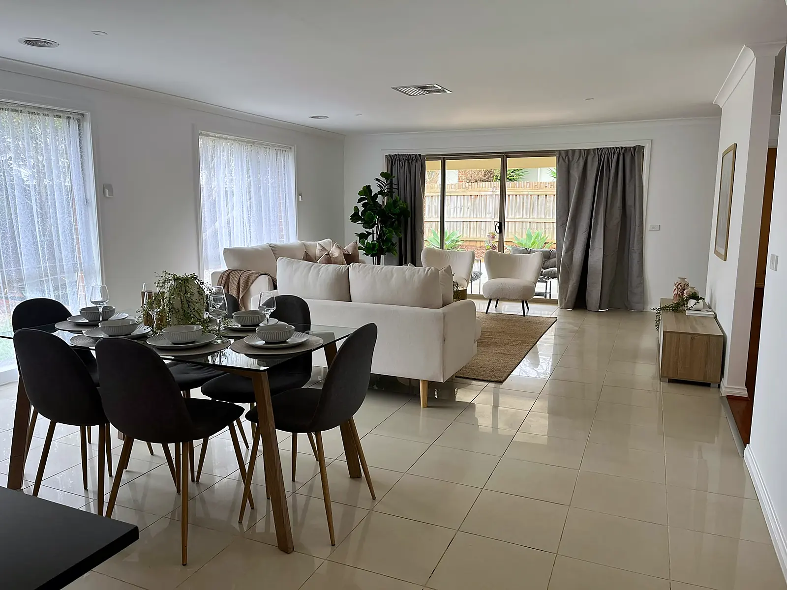 Dining table with the family room behind in a staged Point Cook home