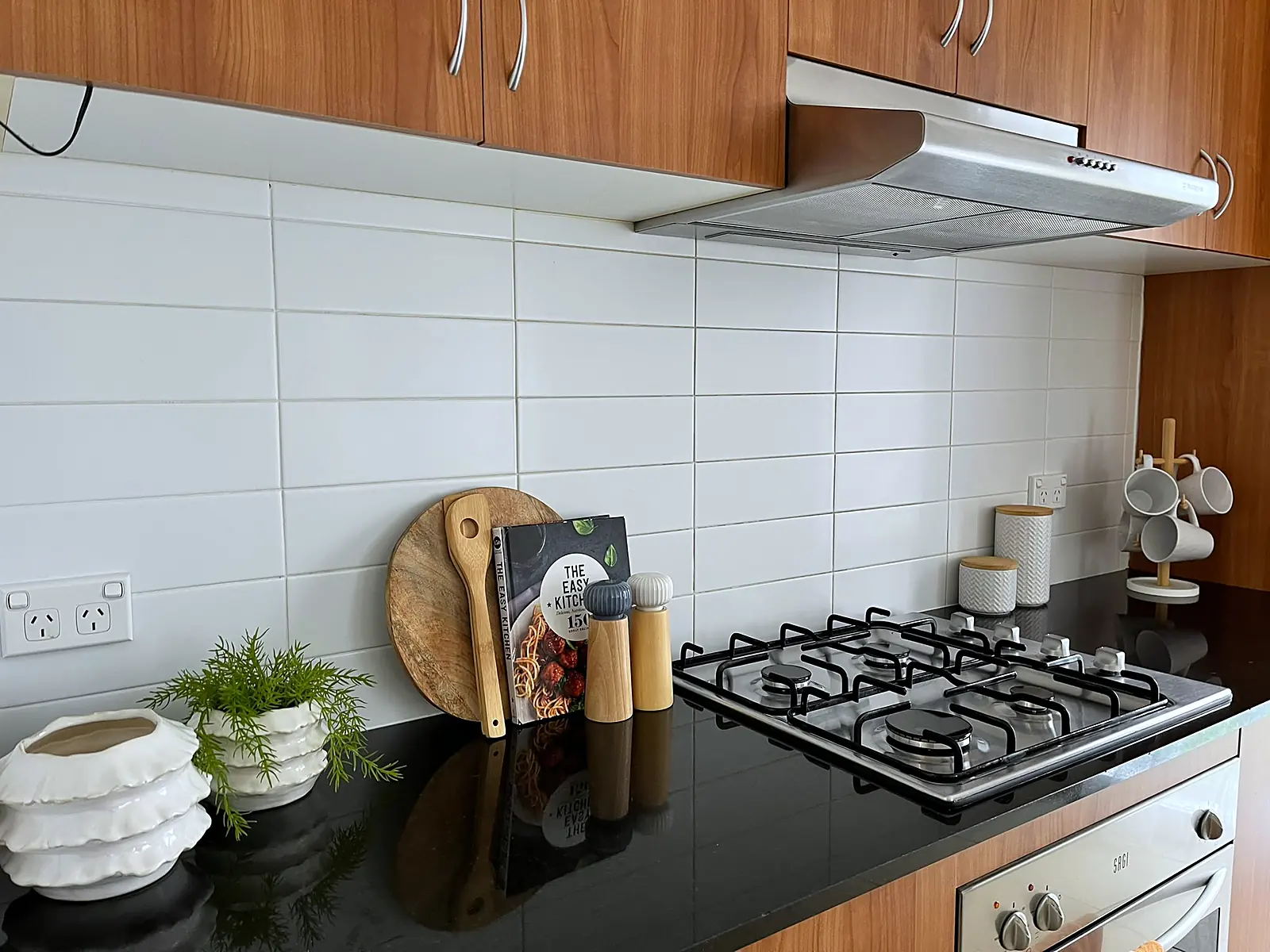 Kitchen bench styled with boards and greenery in a Point Cook home