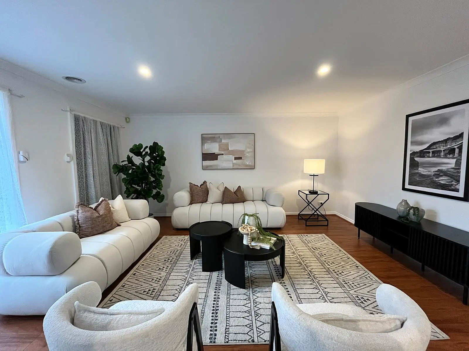 Formal lounge staged with curved cream sofas and patterned rug in a Point Cook home