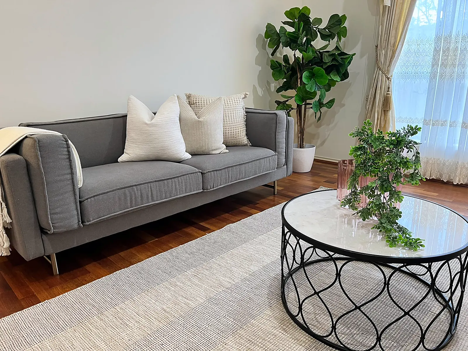 Lounge styled with grey sofa and round coffee table in a Roxburgh Park home