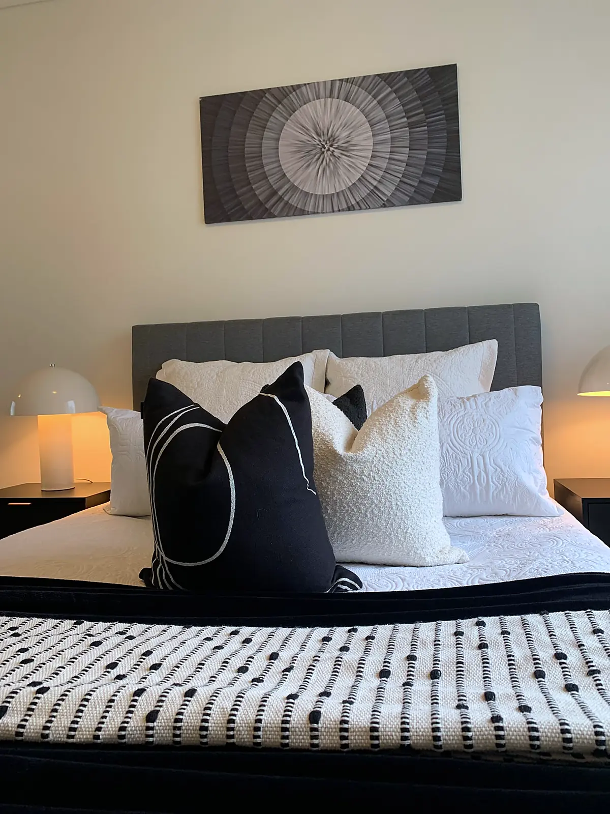 Bedroom styled with black and white cushions and throw in a Southbank apartment
