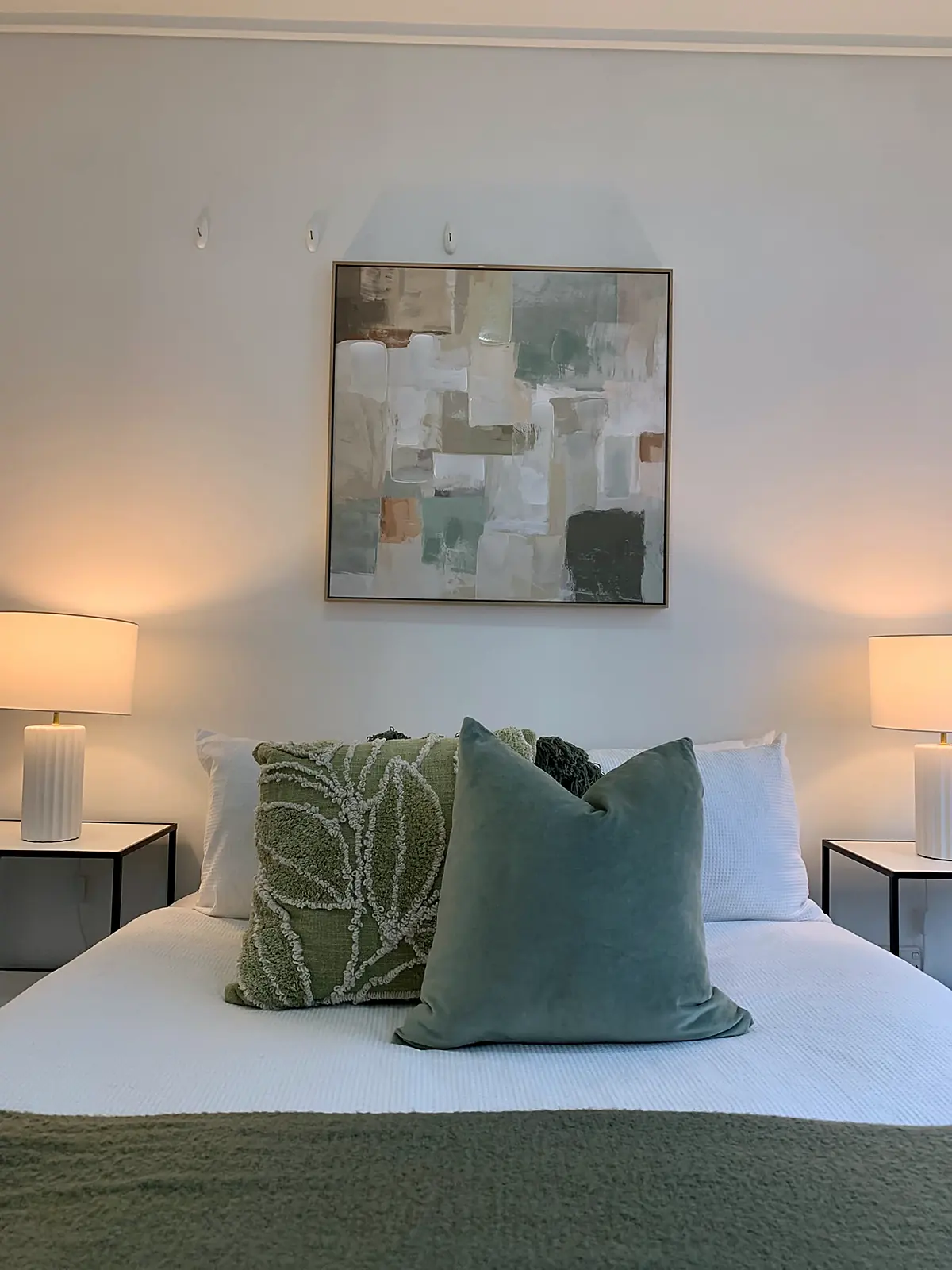 Bedroom staged with green cushions and abstract artwork in a Southbank apartment