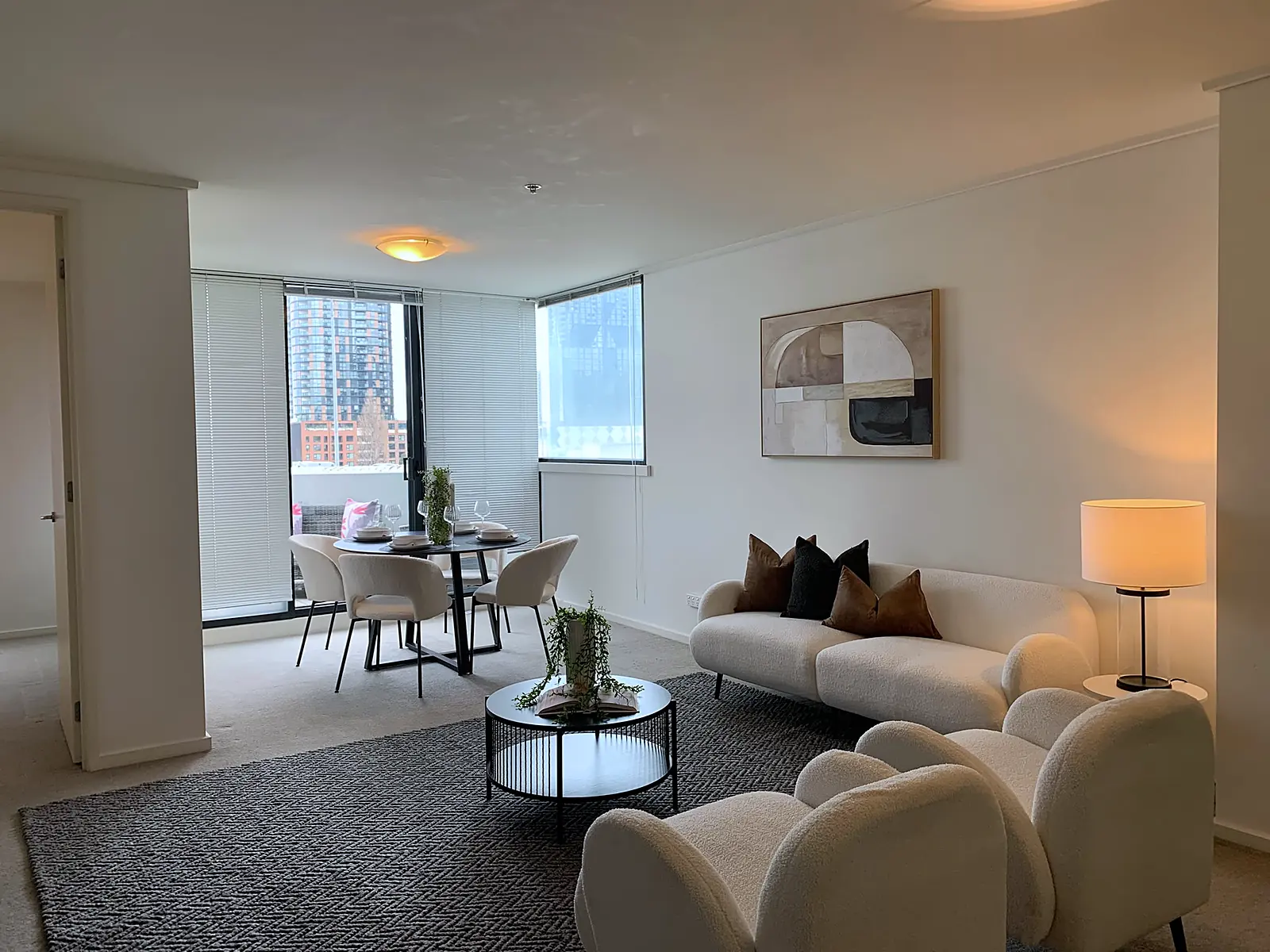 Apartment living and dining room staged with boucle sofa and armchairs in Southbank