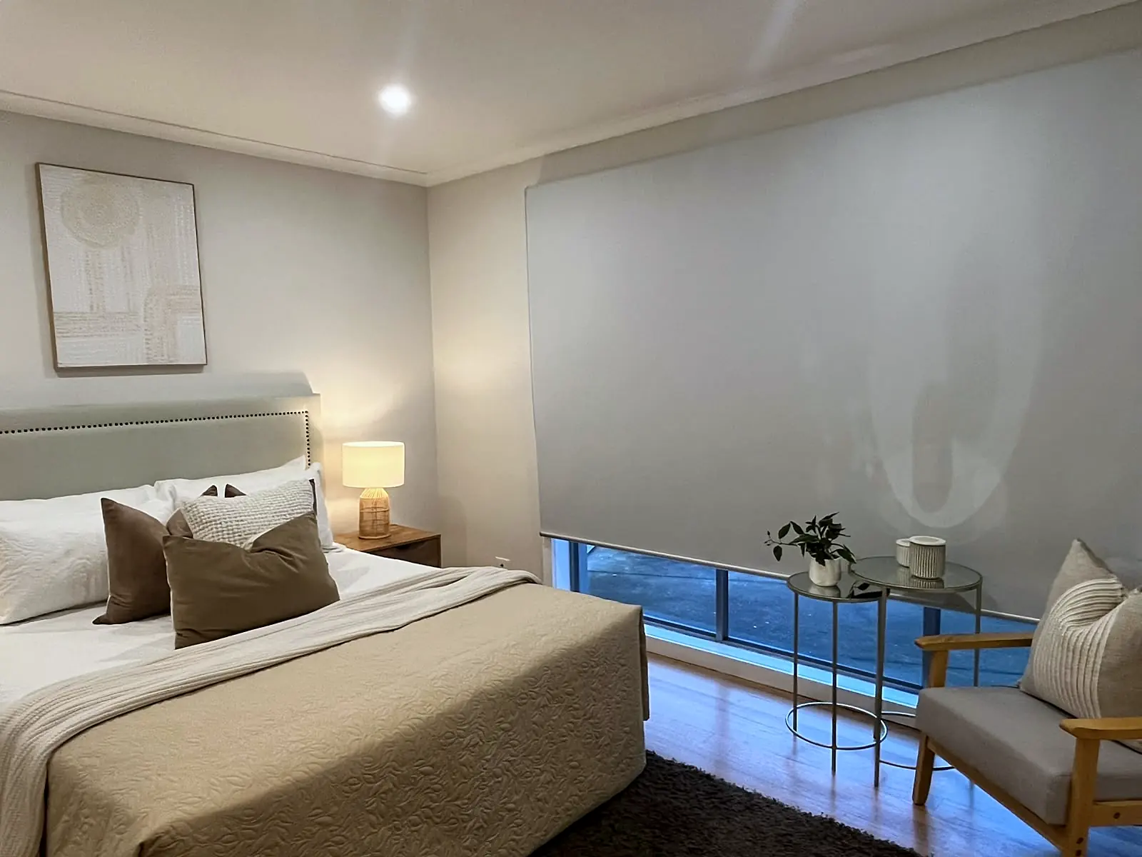 Main bedroom staged with neutral linen and armchair in a St Albans home