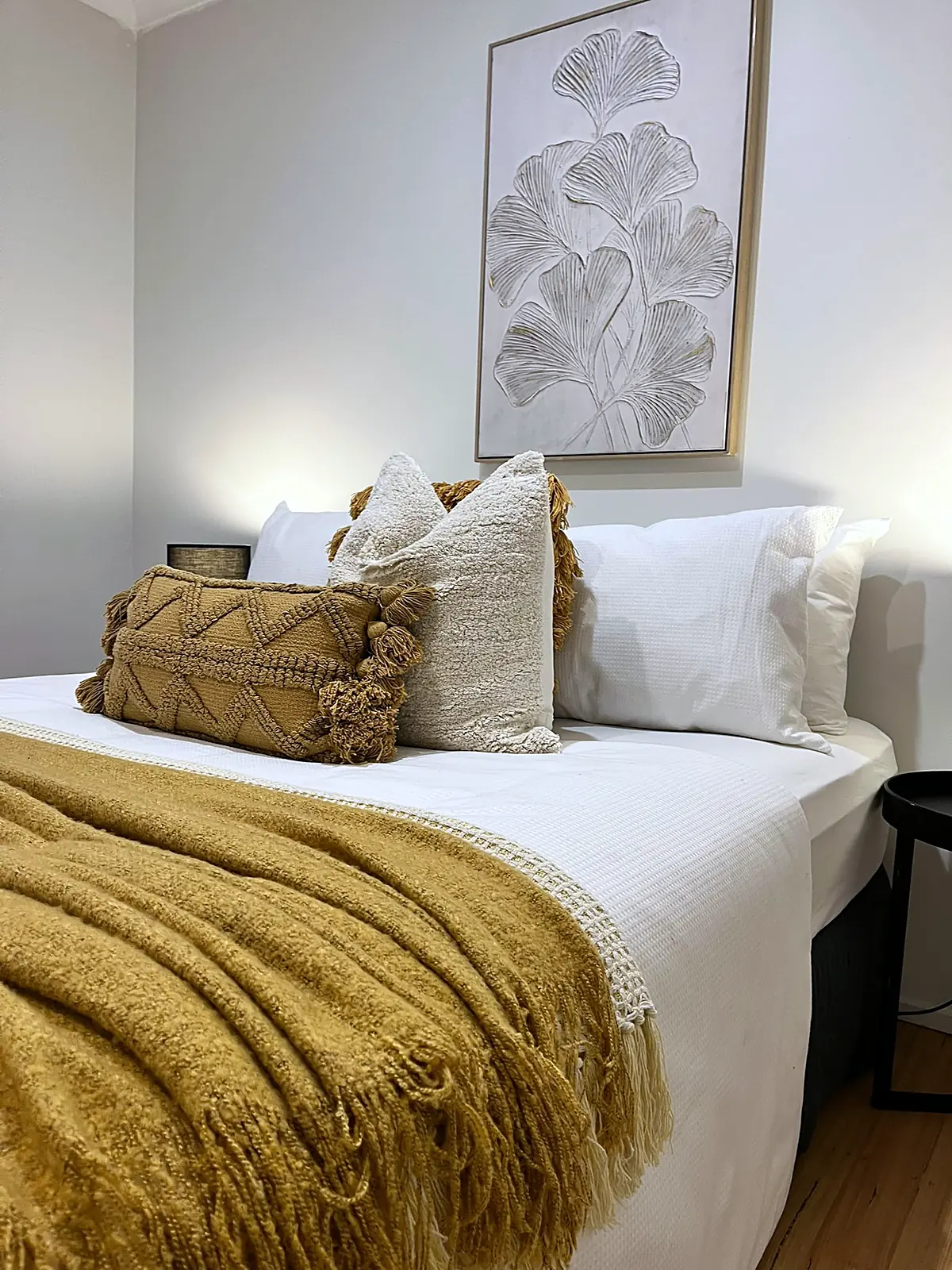 Bedroom staged with mustard throw and textured cushions in a St Albans home