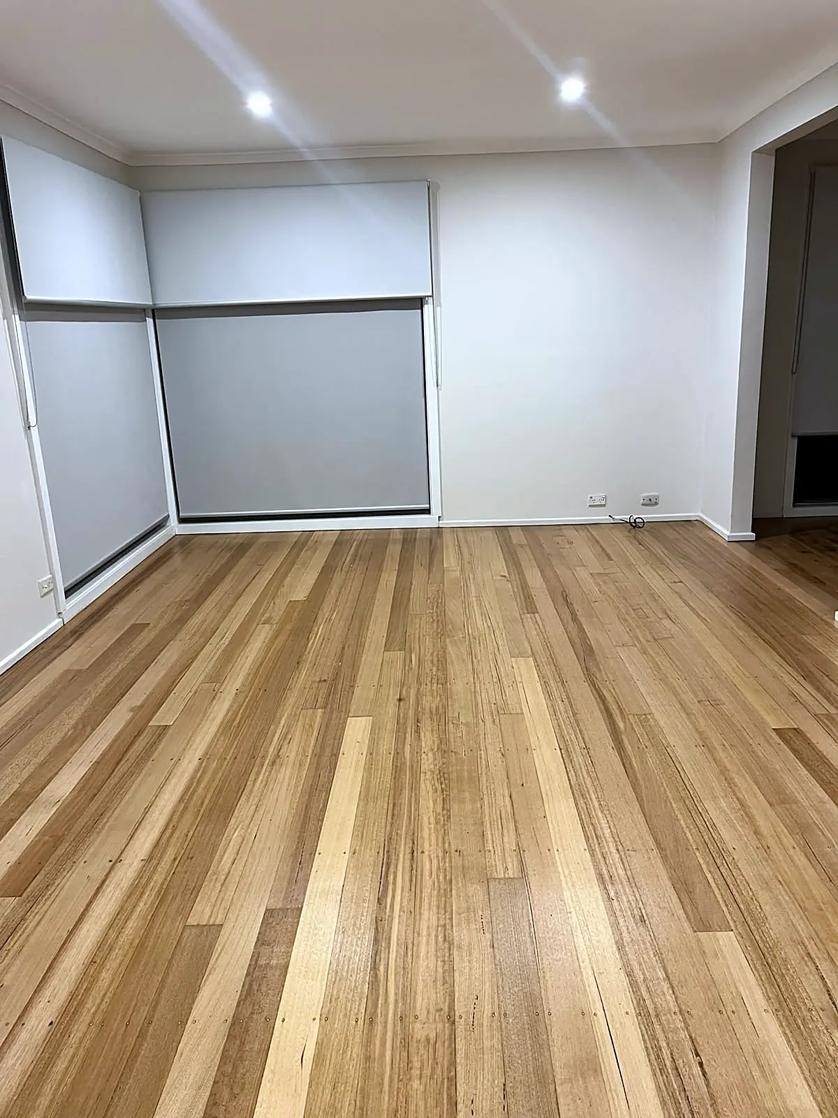 Empty living room with polished timber floor before staging in a St Albans home
