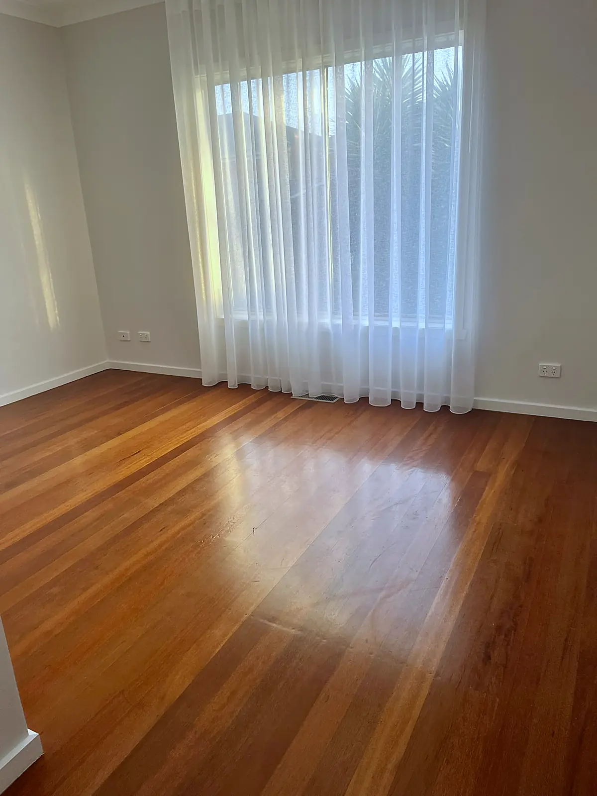 Empty room with polished timber floor before staging in a Sunshine home