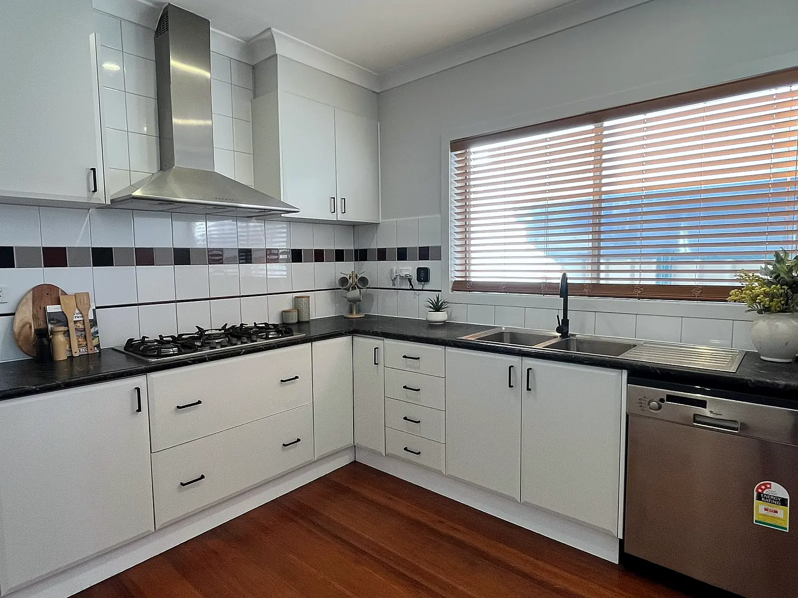 White kitchen with timber floor styled for sale in a Sunshine home