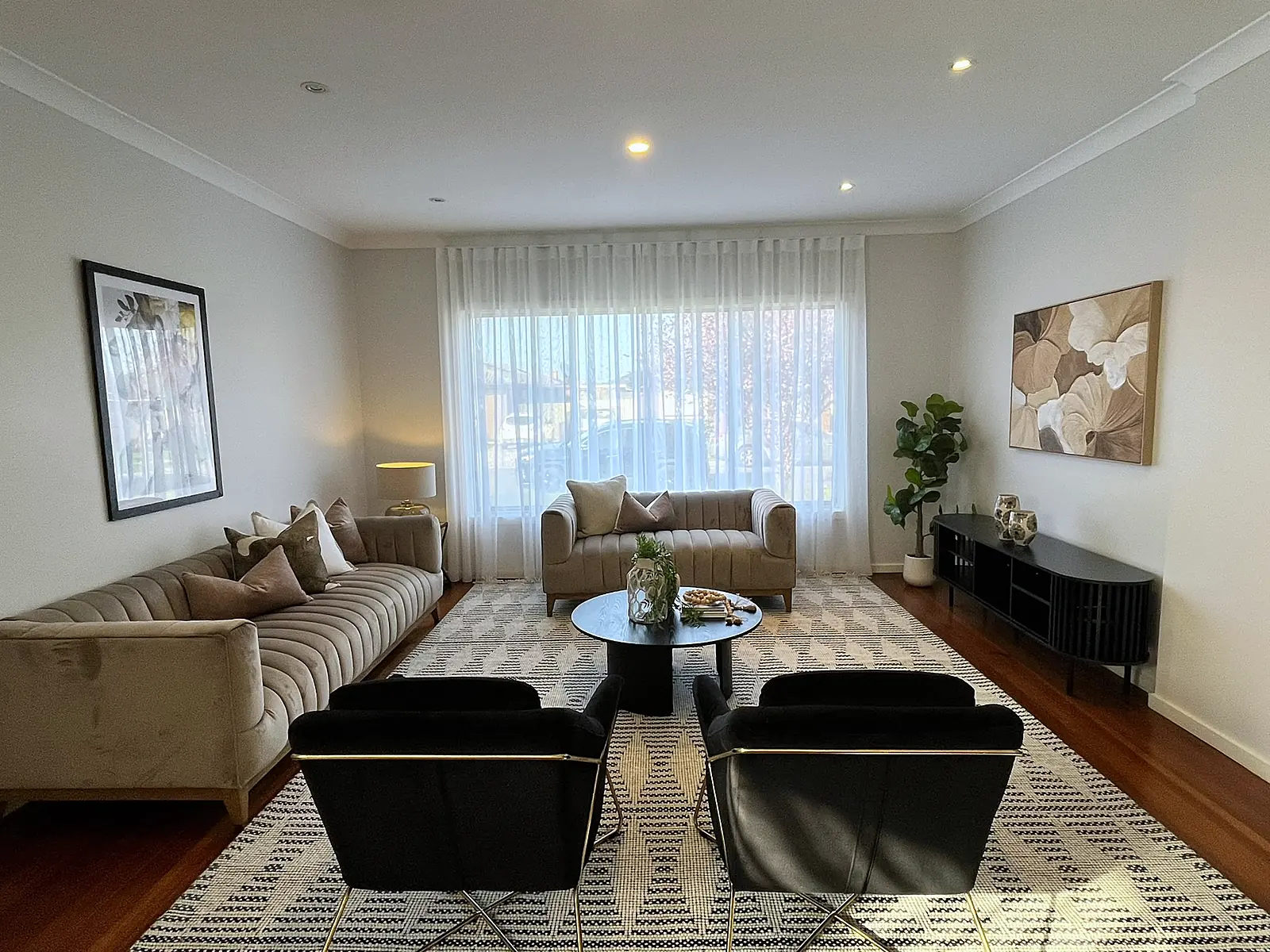 Living room styled with black armchairs and sheer curtains in a Sunshine home