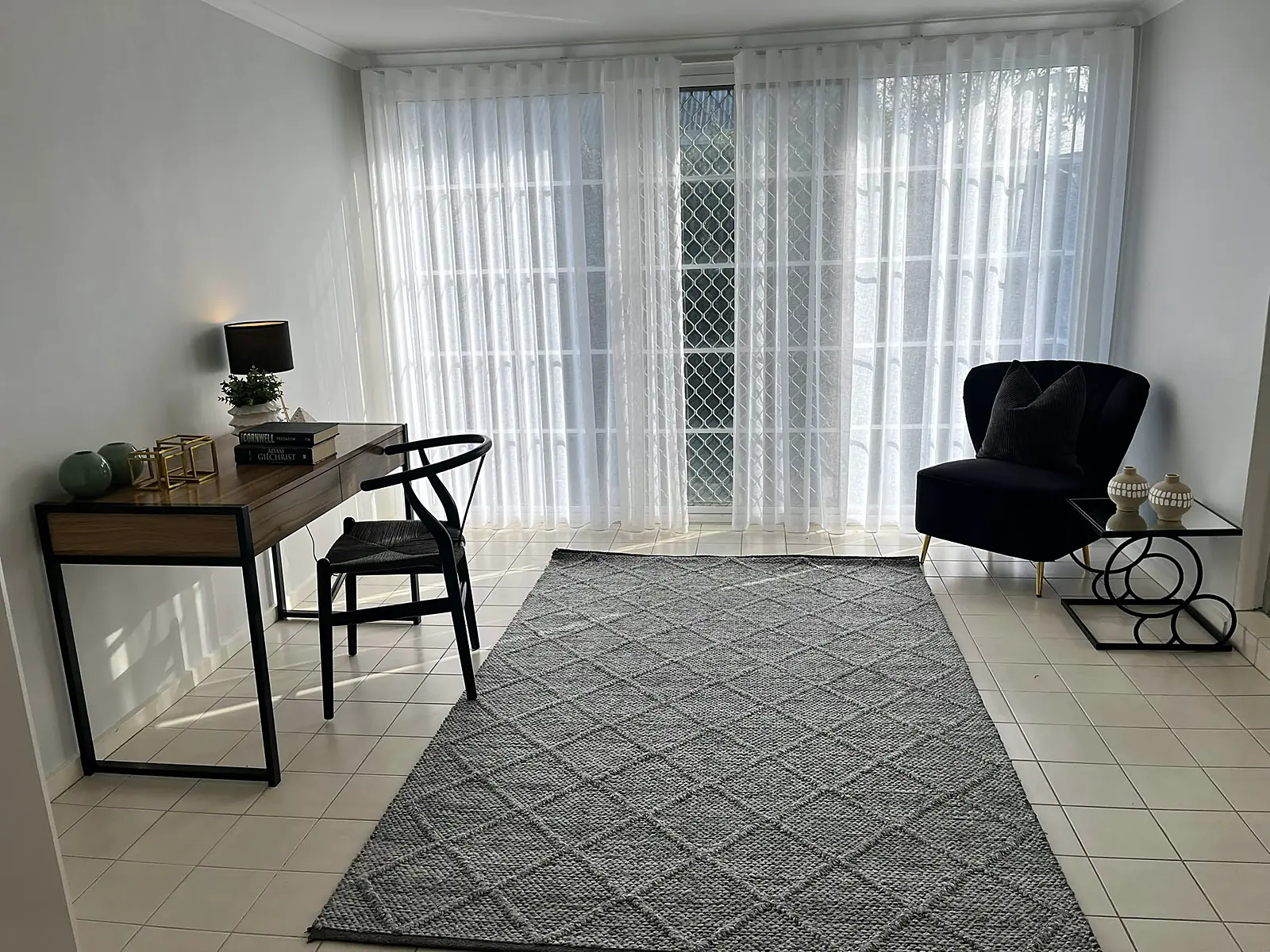Sunroom staged as a study with desk and armchair in a Sunshine home