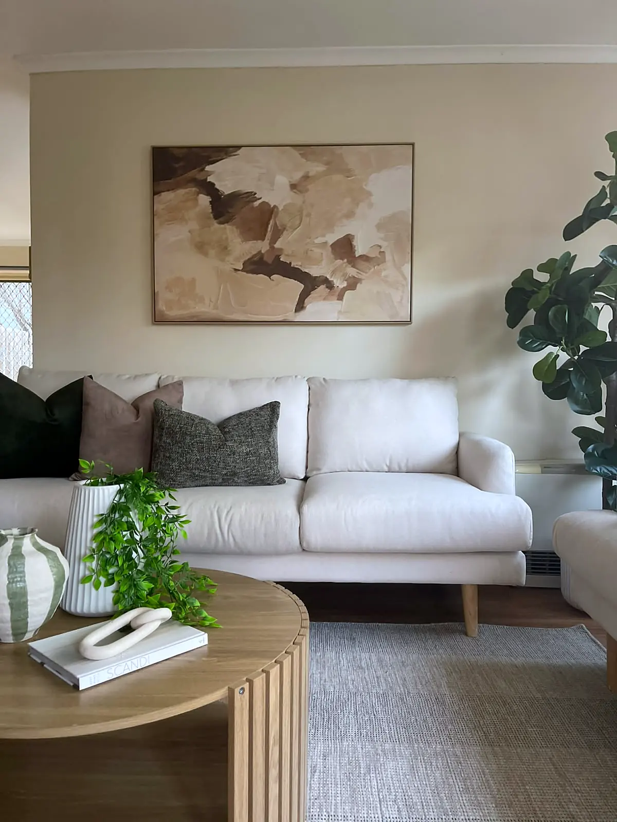 Lounge staged with cream sofa and earthy artwork in a Sydenham unit
