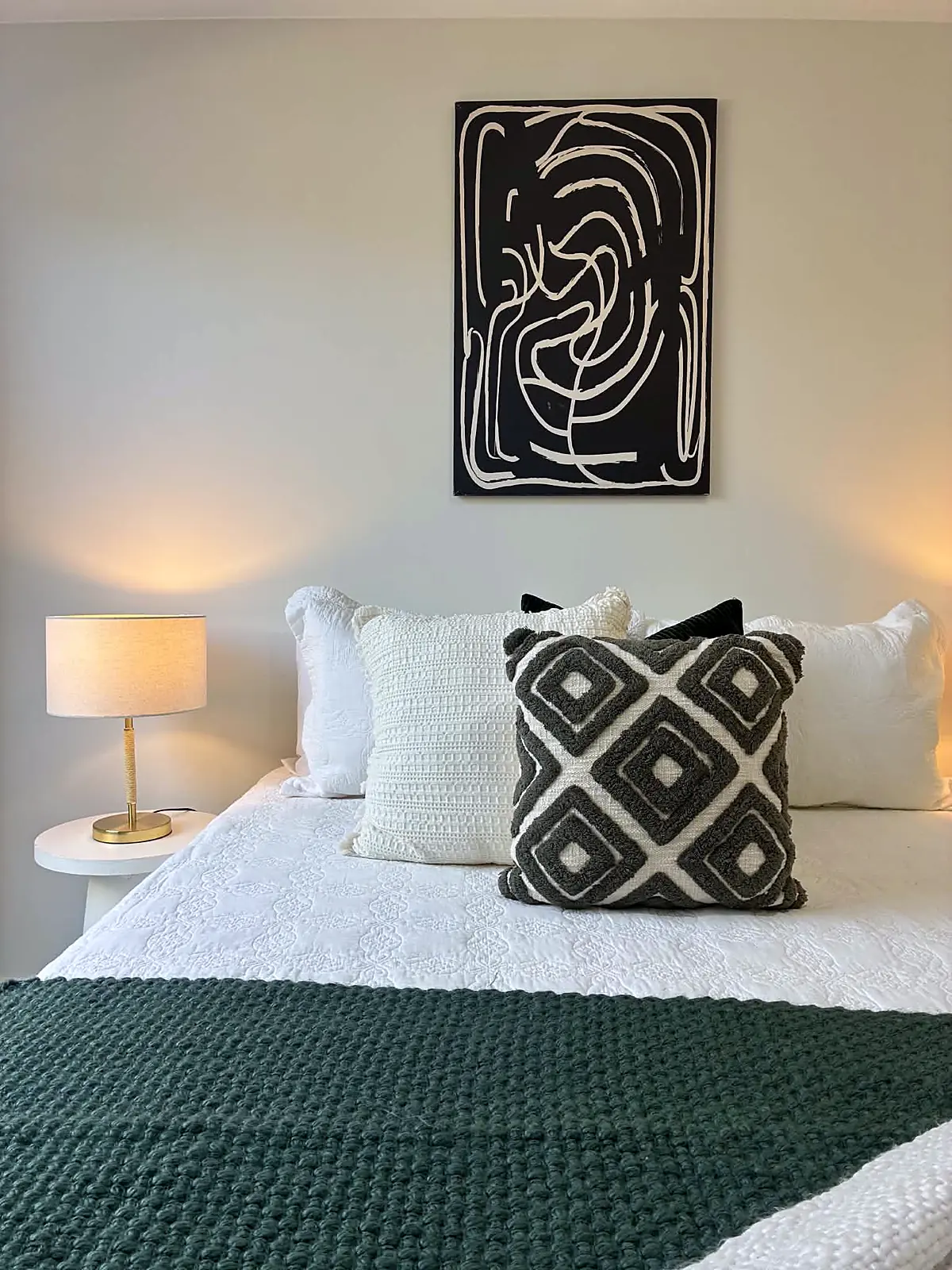 Bedroom styled with dark green throw and line-art print in a Tarneit home