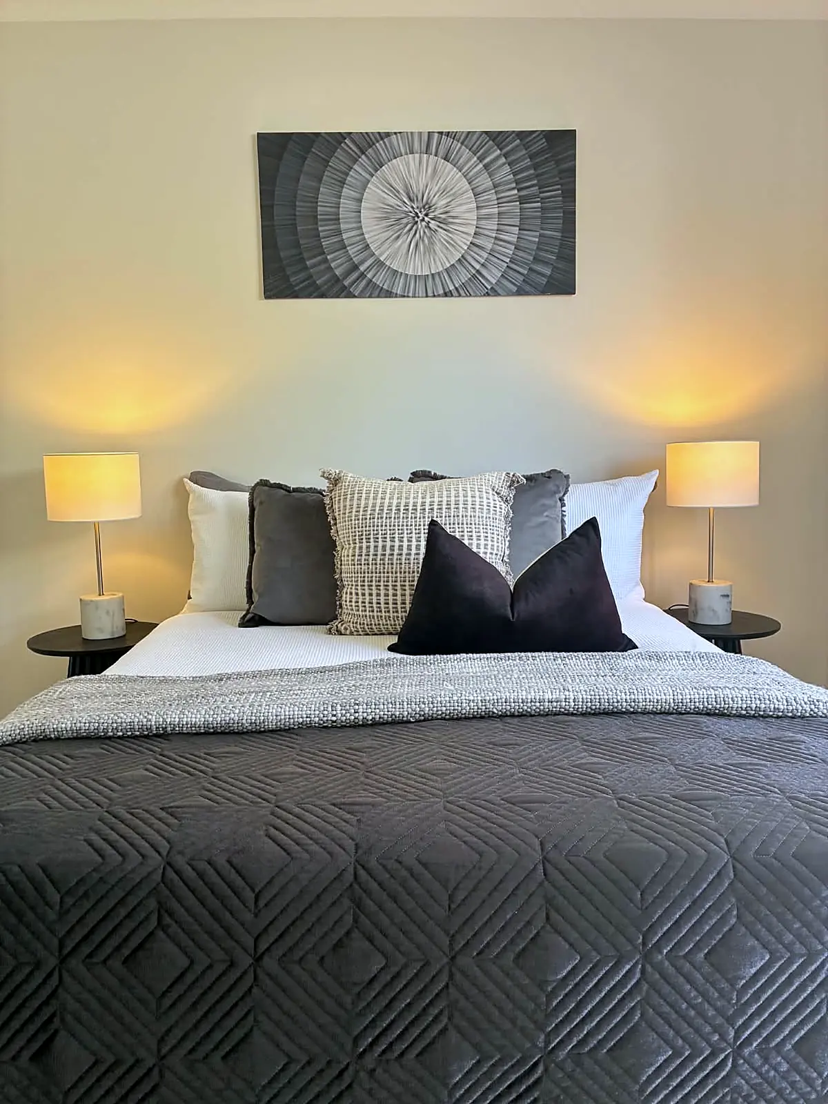 Master bedroom styled with grey quilt and bedside lamps in a Tarneit home