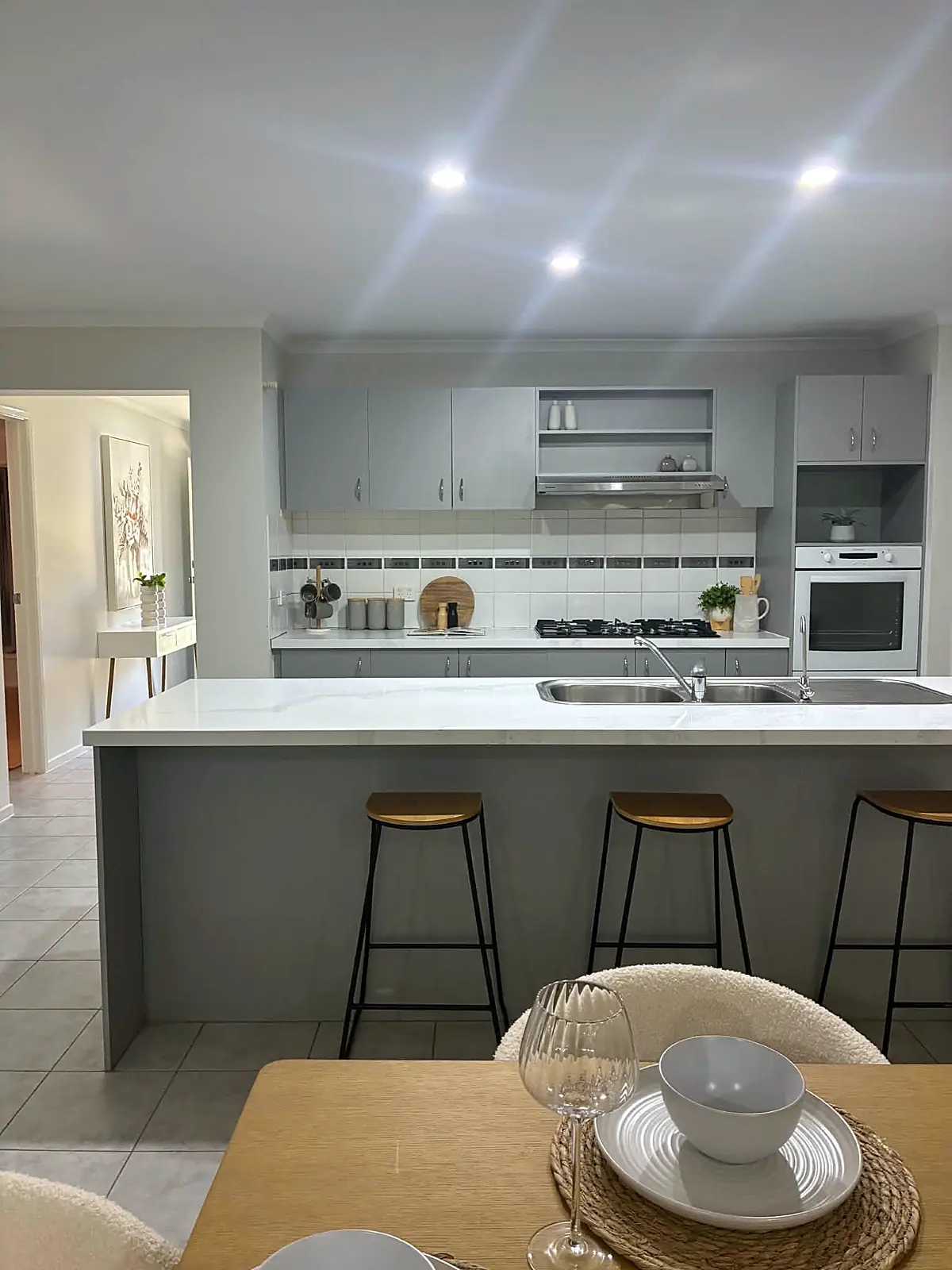 Kitchen with island bench and bar stools in a staged Tarneit home