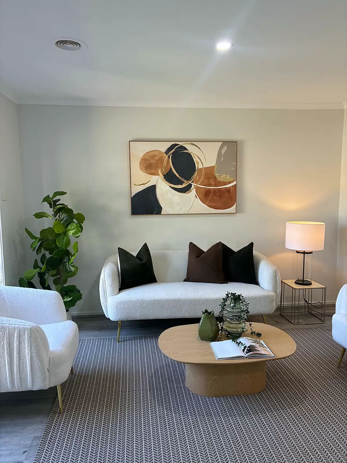Lounge staged with white sofa and round timber coffee table in a Tarneit home