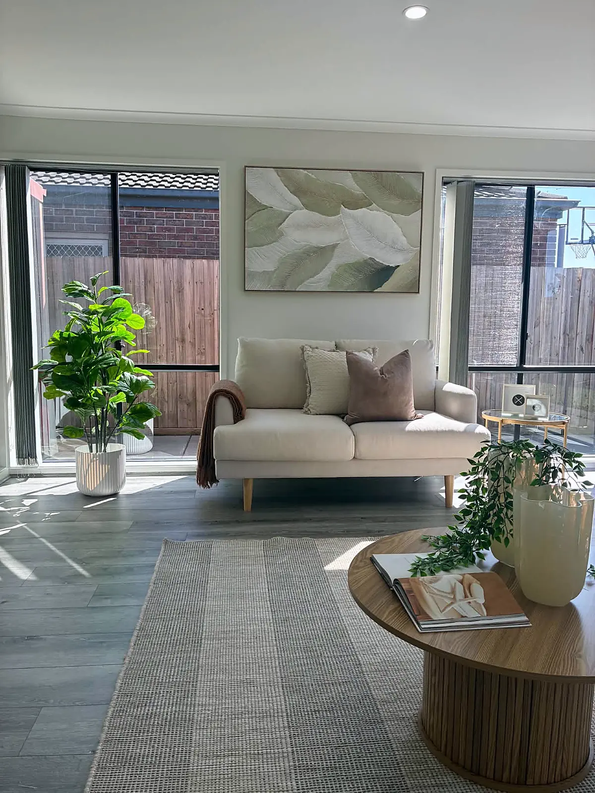 Family room staged with cream sofa beside garden windows in Tarneit