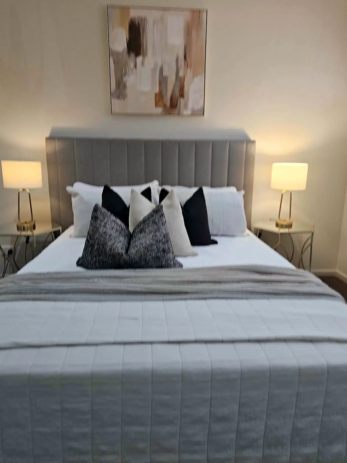 Main bedroom staged with grey bedhead and black and white cushions in a Taylors Hill home