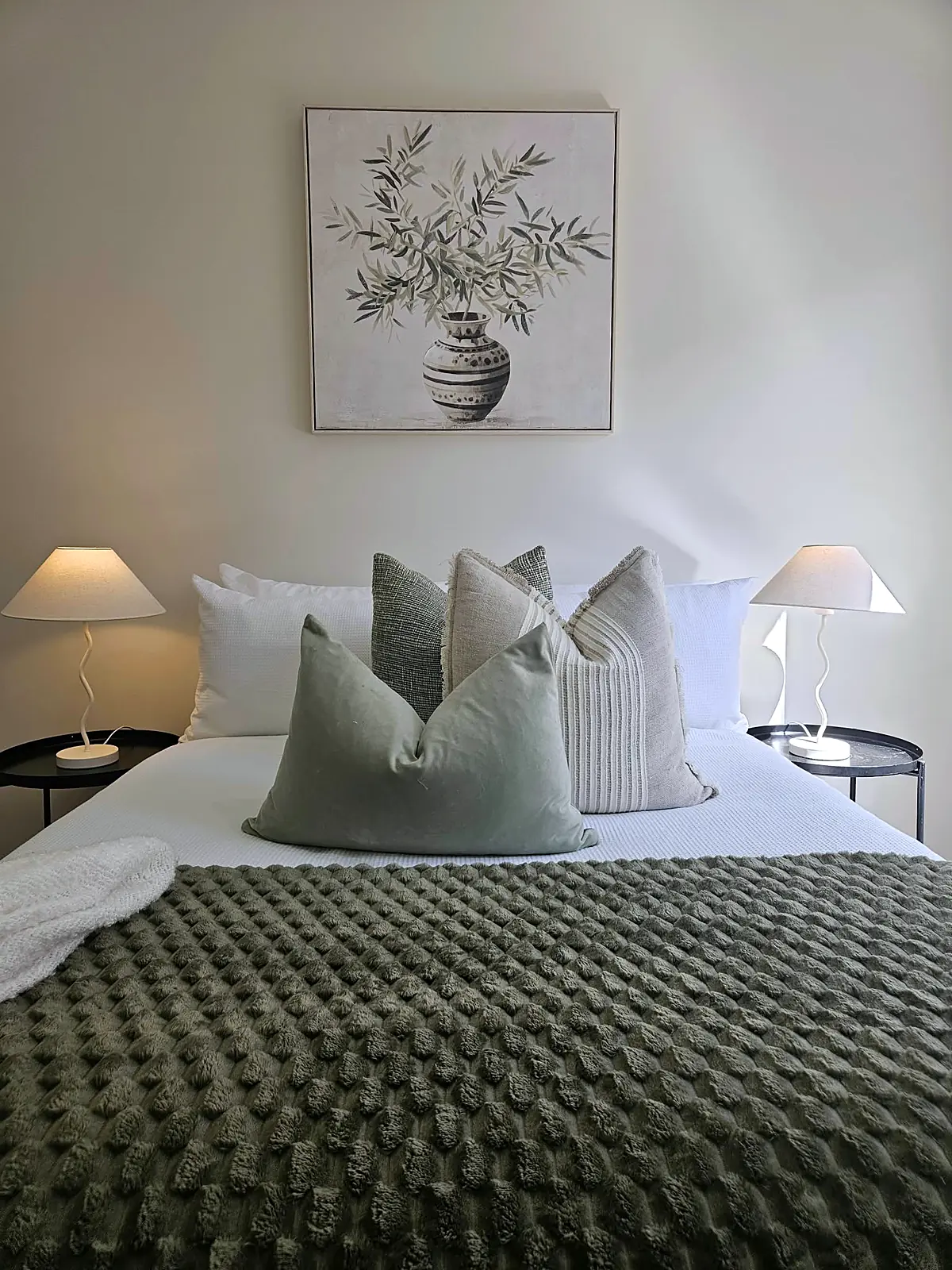 Bedroom styled with sage green cushions and botanical artwork in a Taylors Hill home