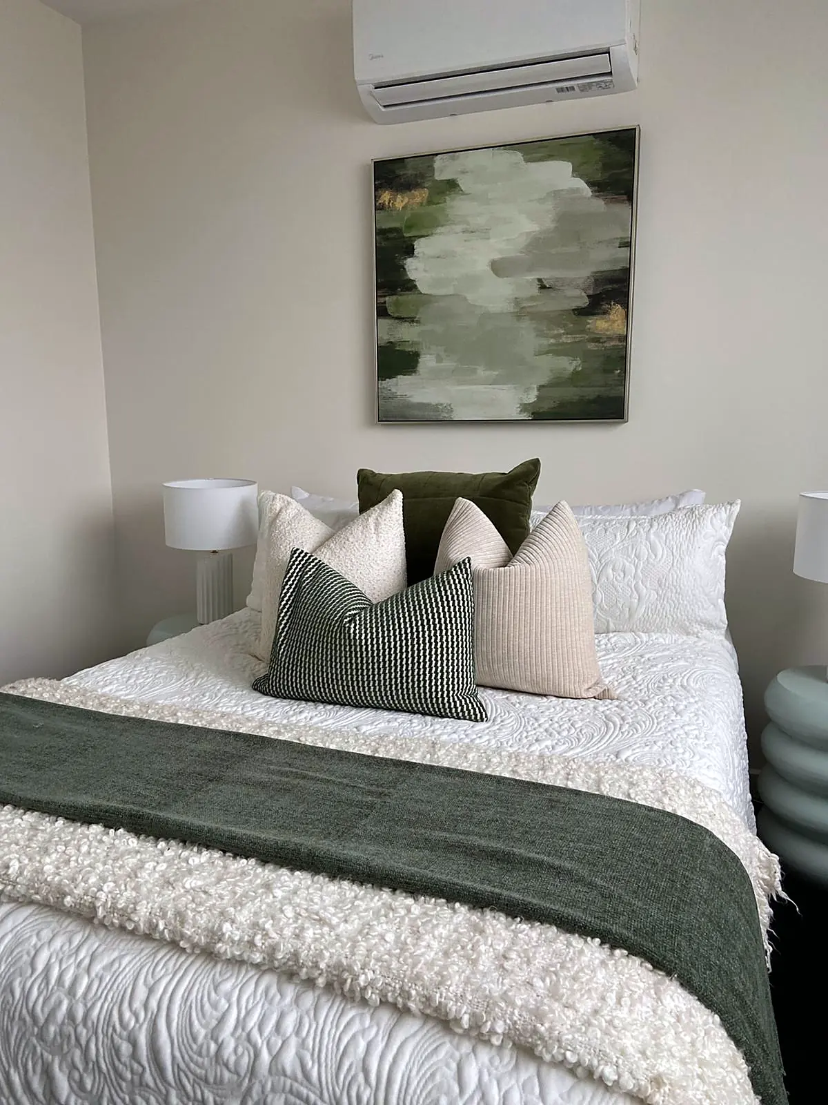 Bedroom styled with forest green throw and abstract artwork in a Thomastown townhouse