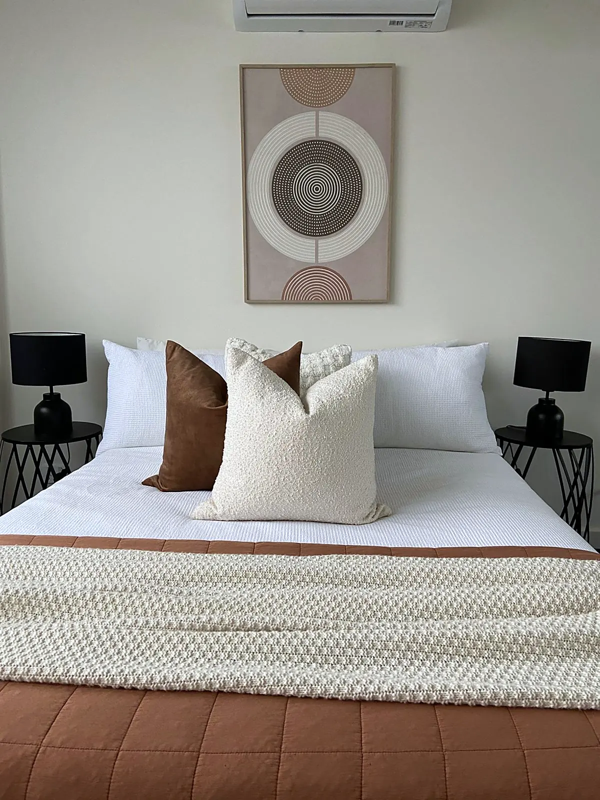 Bedroom staged with terracotta quilt and black lamps in a Thomastown townhouse