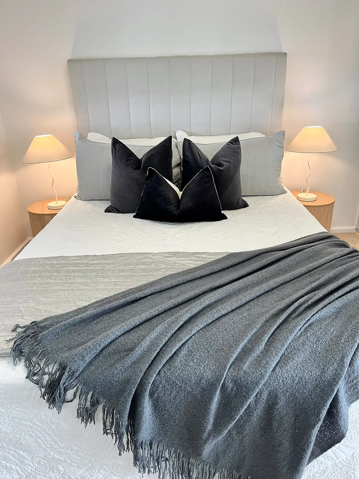 Bed styled with charcoal cushions and fringed throw in a Thornbury unit