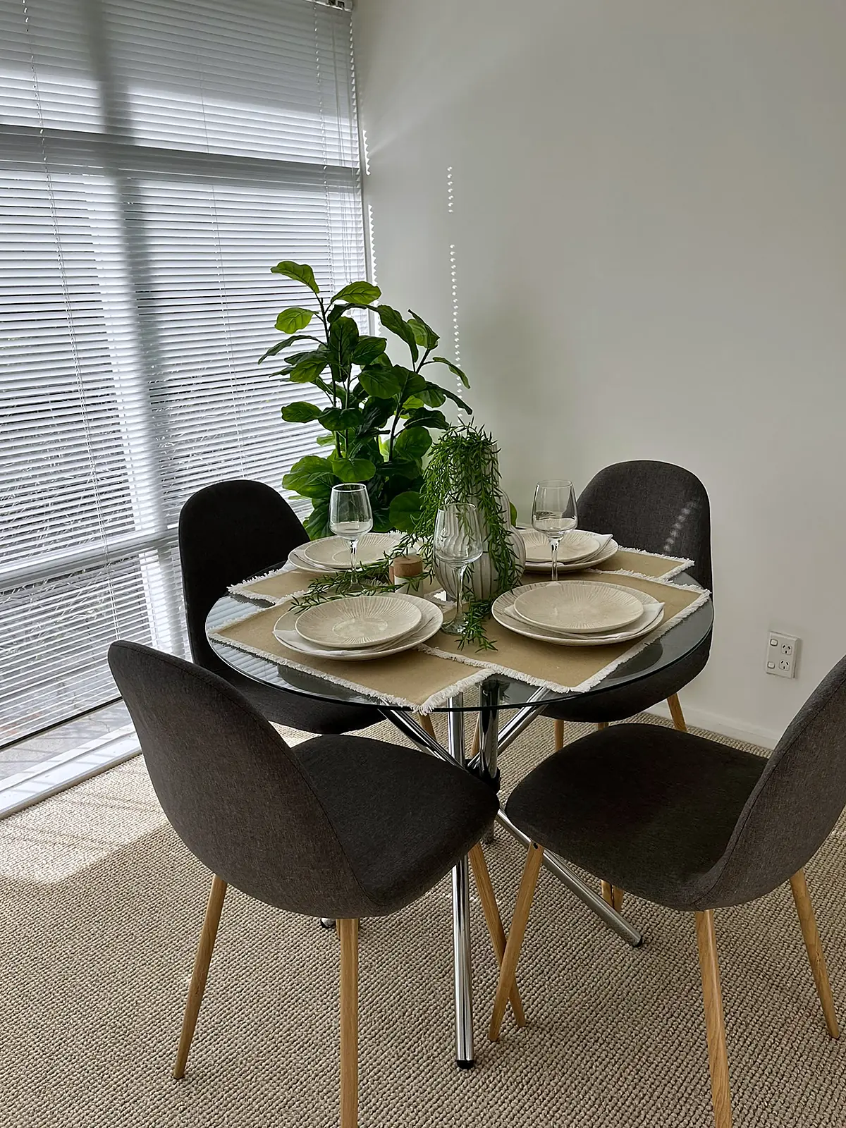 Round glass dining table for four in a staged Thornbury unit