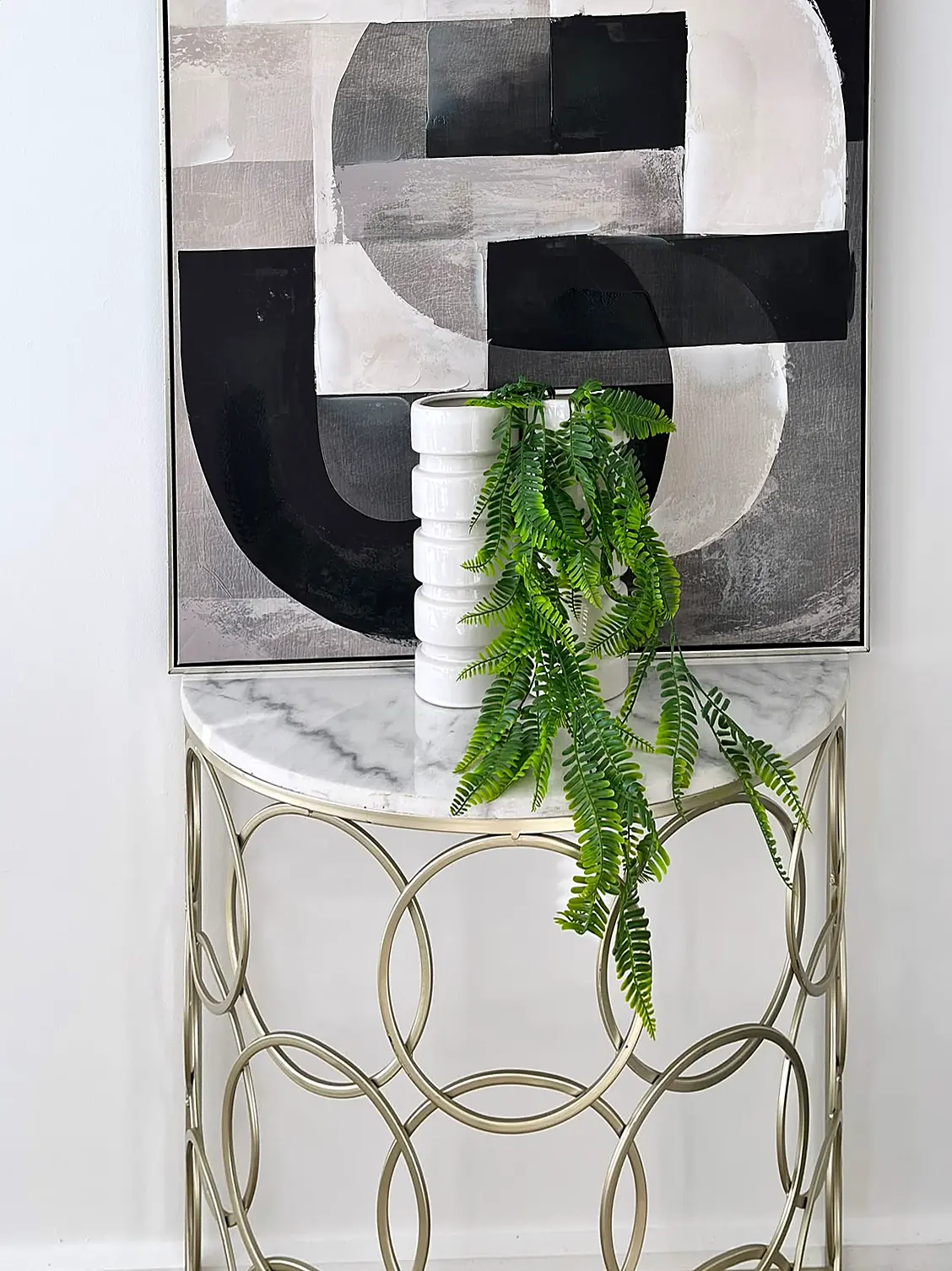 Console table with abstract artwork and greenery in a Thornbury unit
