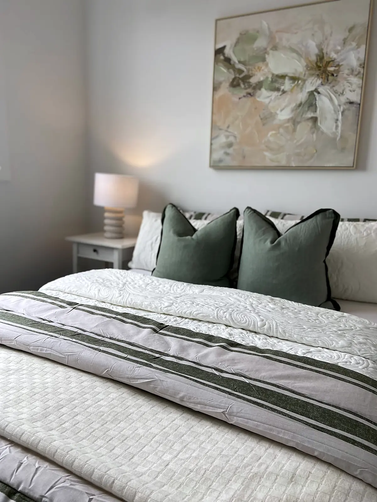 Bedroom styled with green cushions and striped throw in a Truganina home