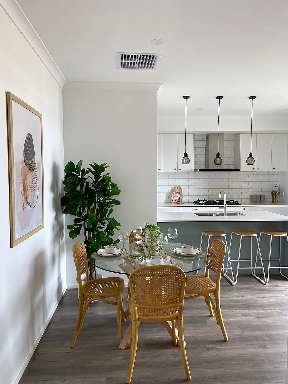 Dining area staged with rattan chairs beside the kitchen in a Truganina home